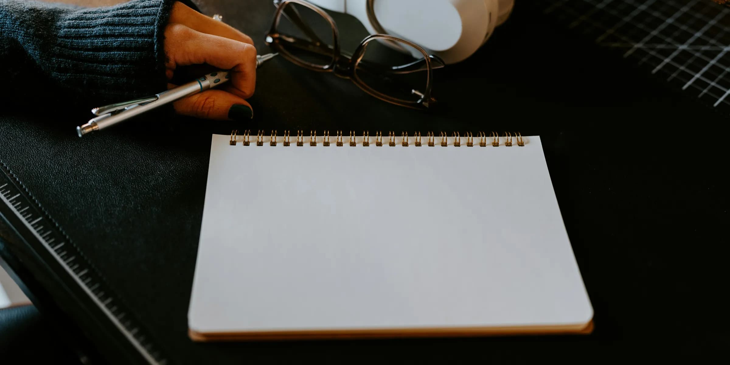 a notepad, pen and headphones on a table