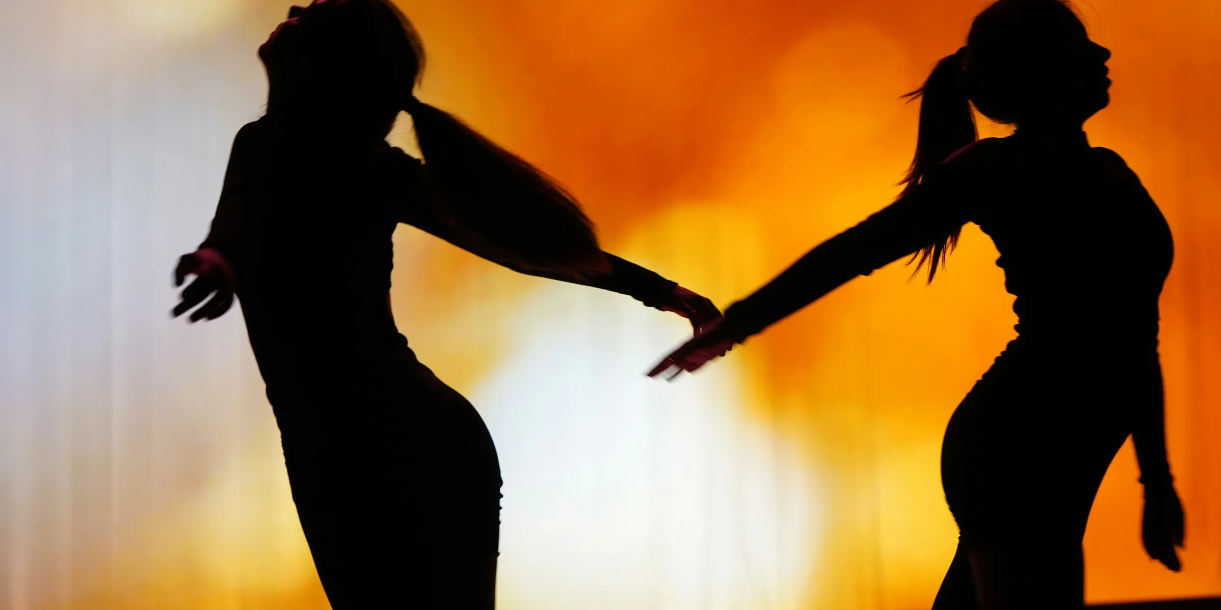 A couple of people that are dancing in the dark