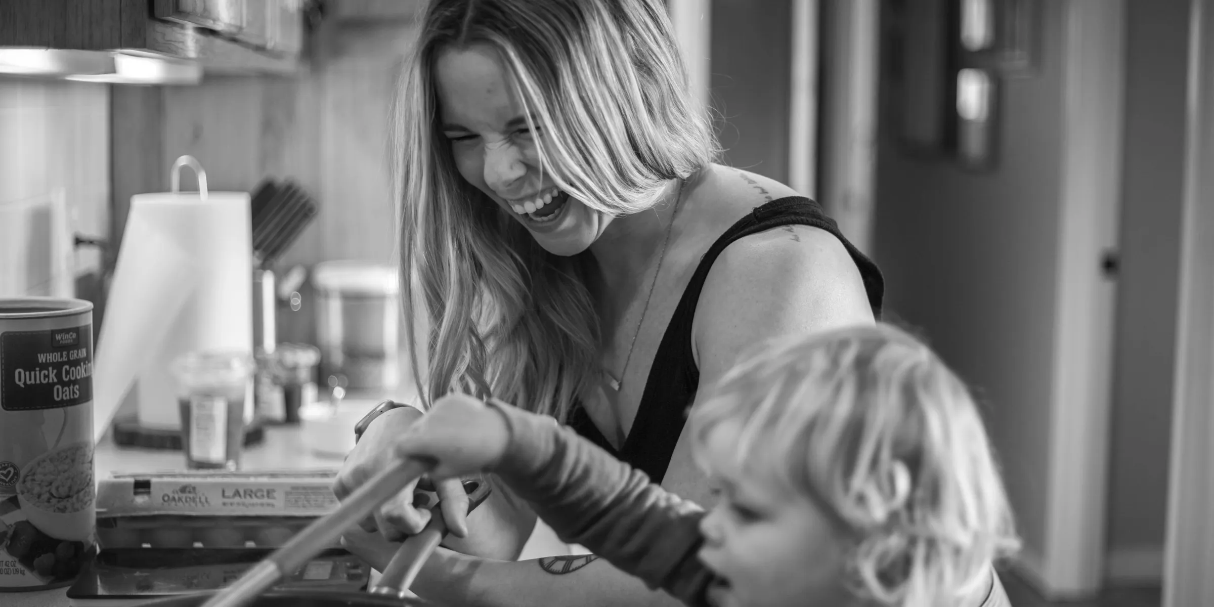 a woman and a child are cooking in the kitchen