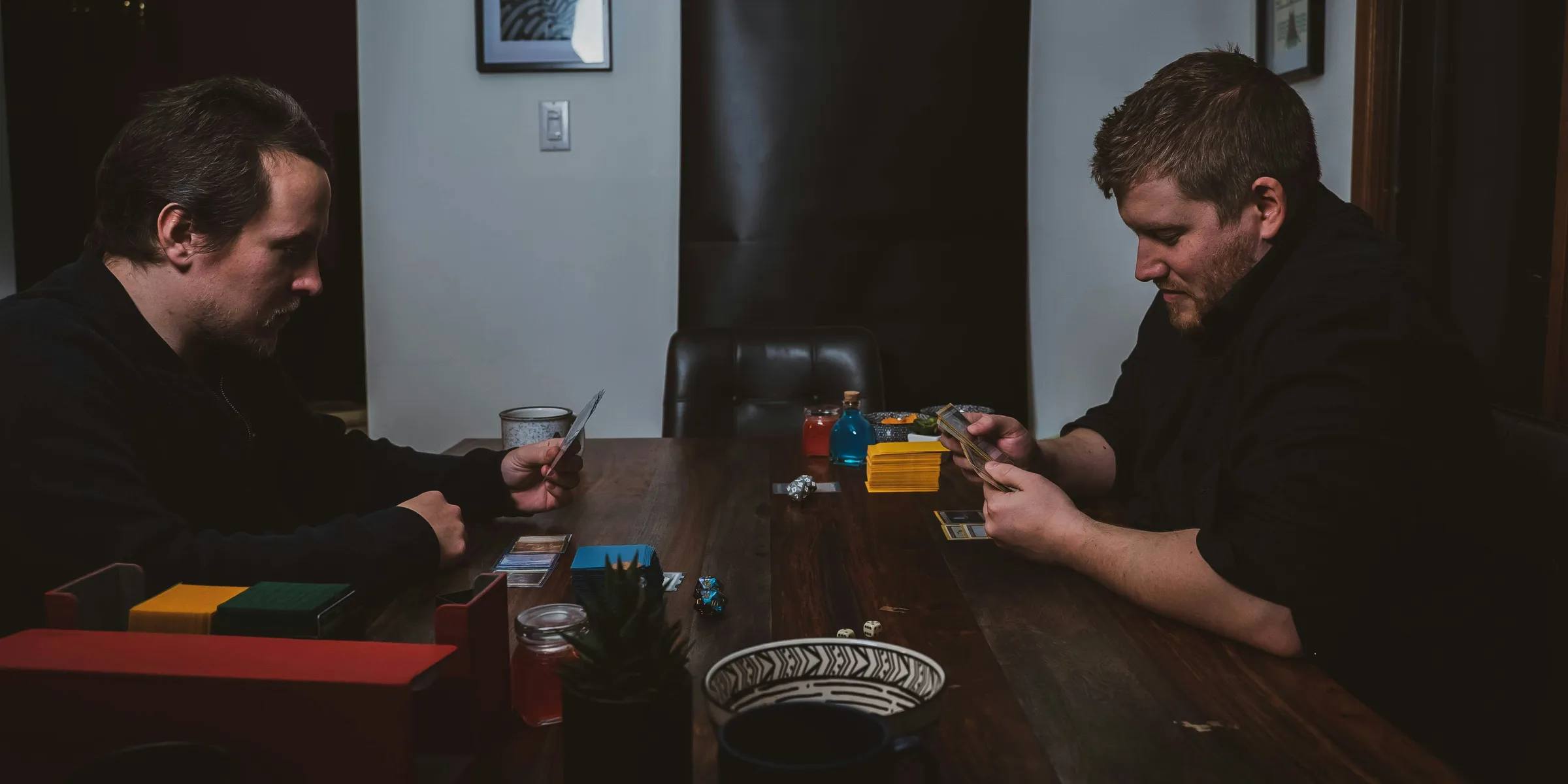 two men sitting at a table playing cards