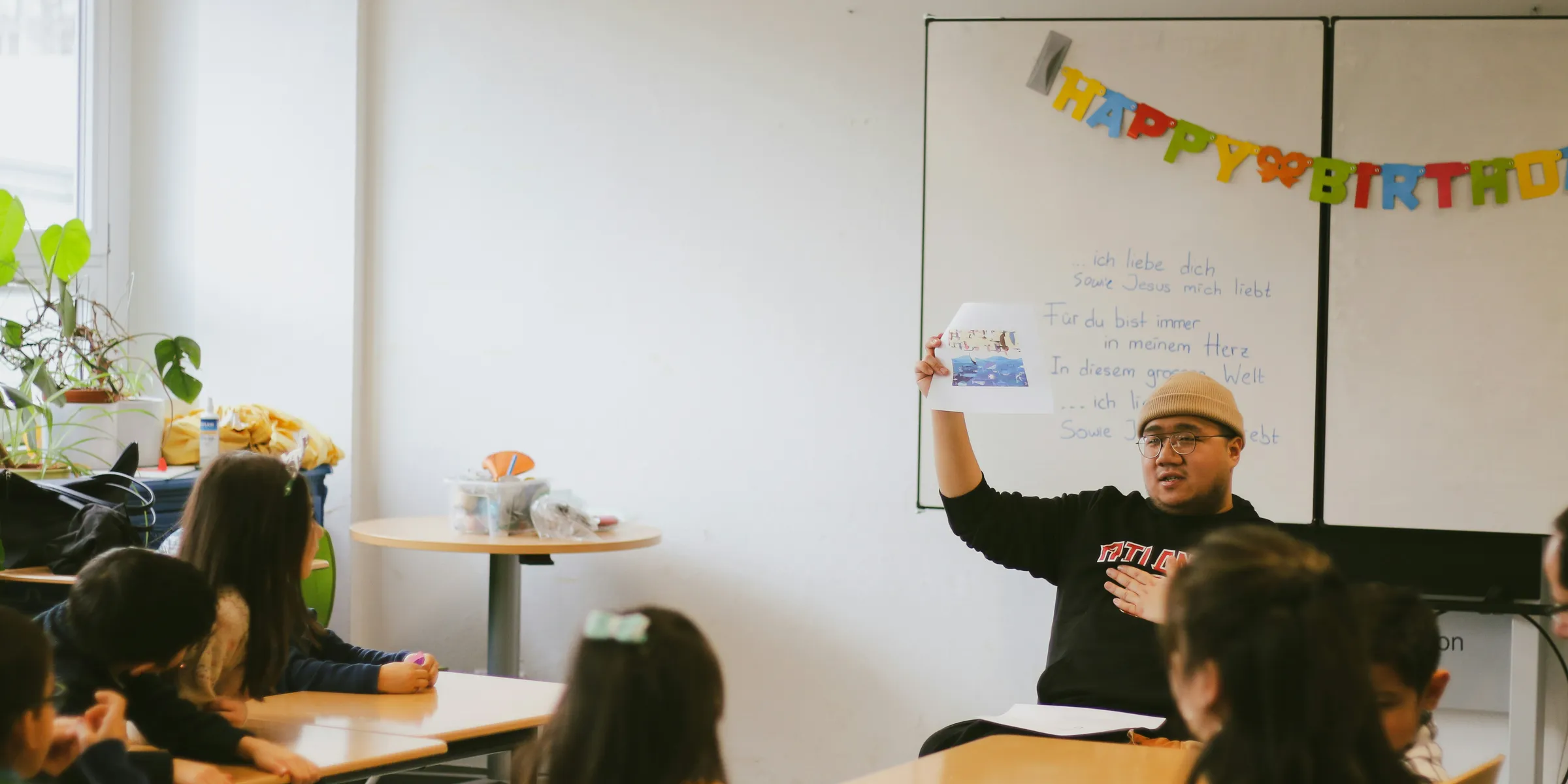 a man standing in front of a whiteboard in a classroom