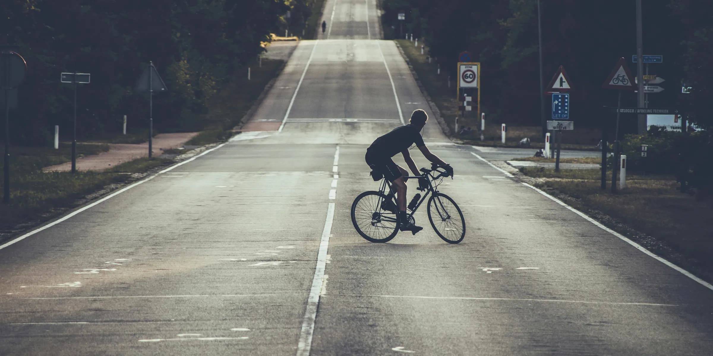 photography of person riding bicycle on road during daytime