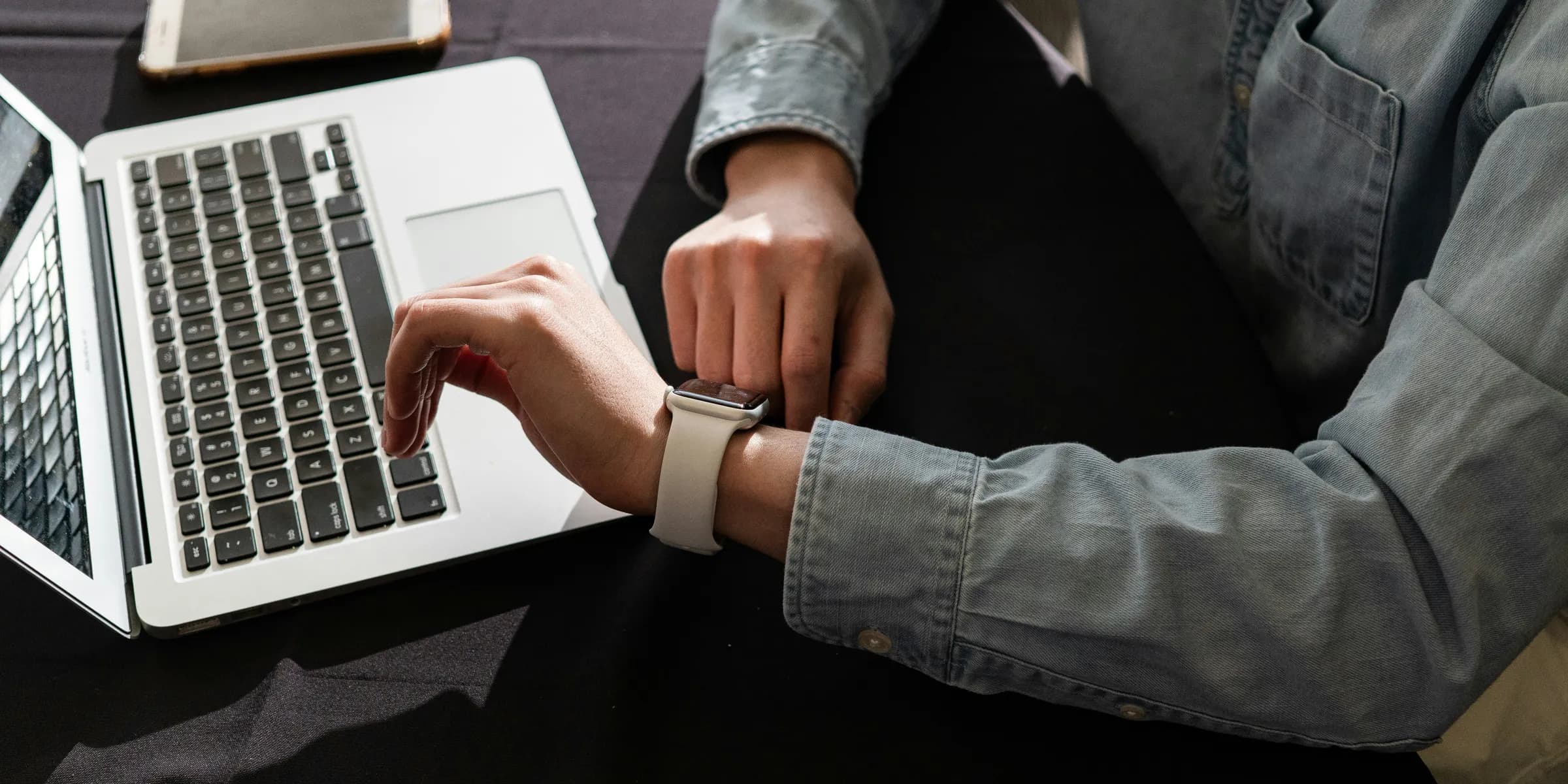 person in blue denim jacket using macbook pro