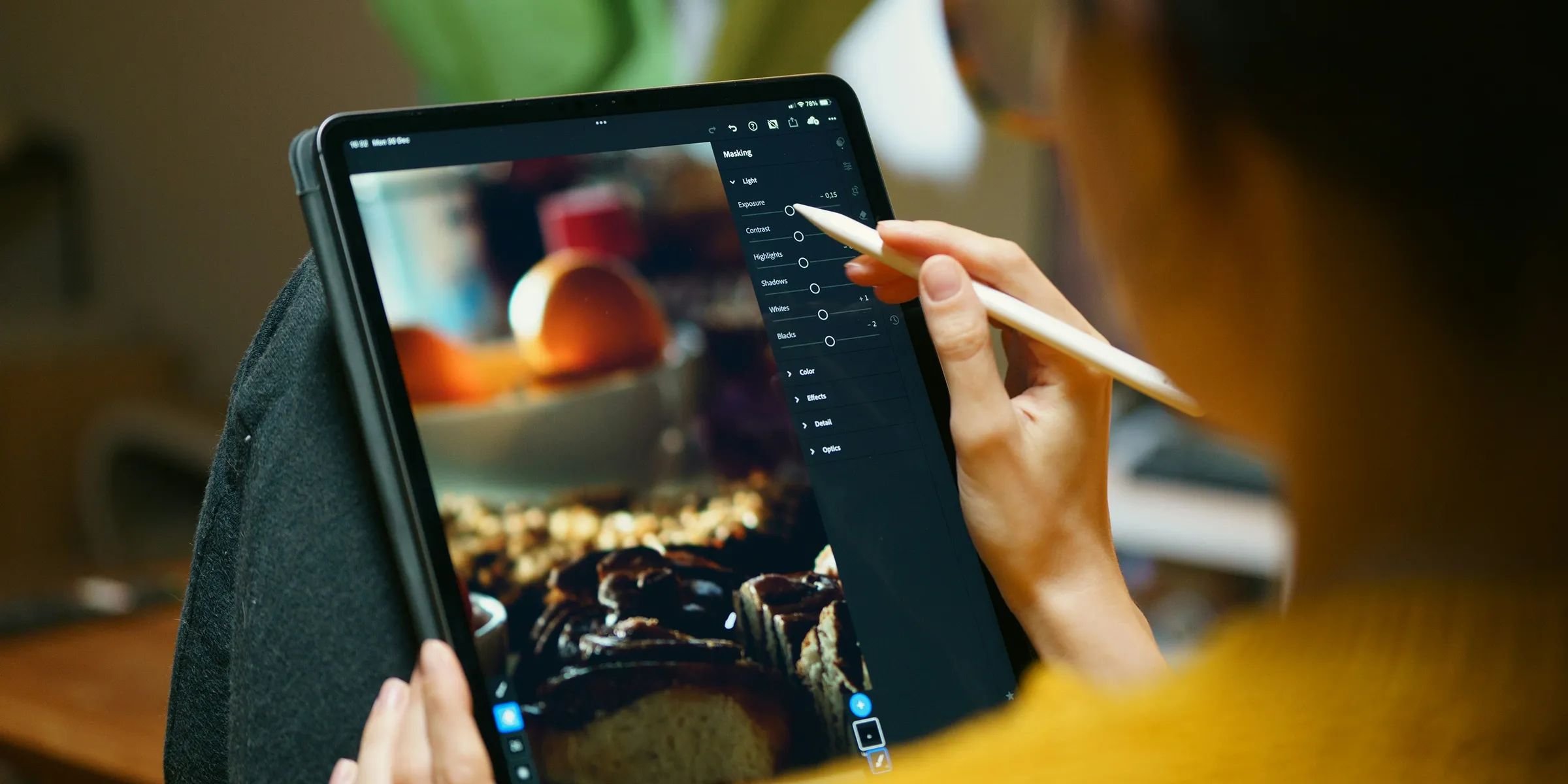 A woman is drawing on a tablet with a pencil