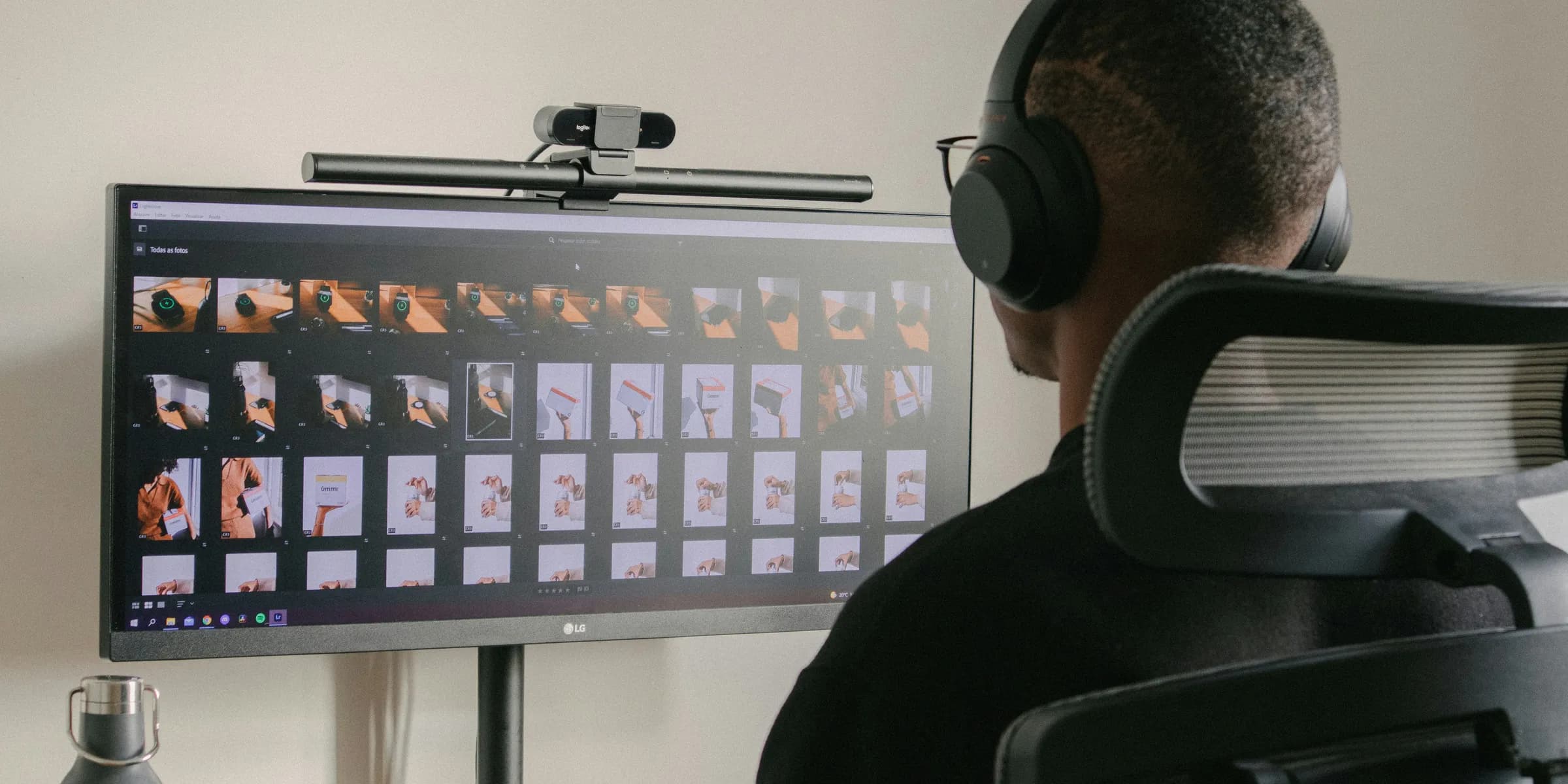 a man sitting in front of a computer monitor wearing headphones
