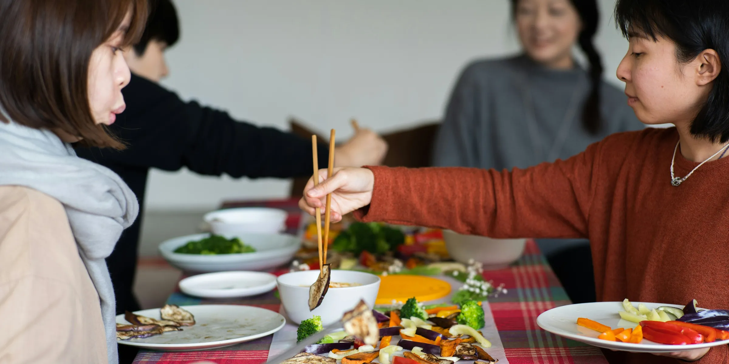 a group of women sitting around a table eating food