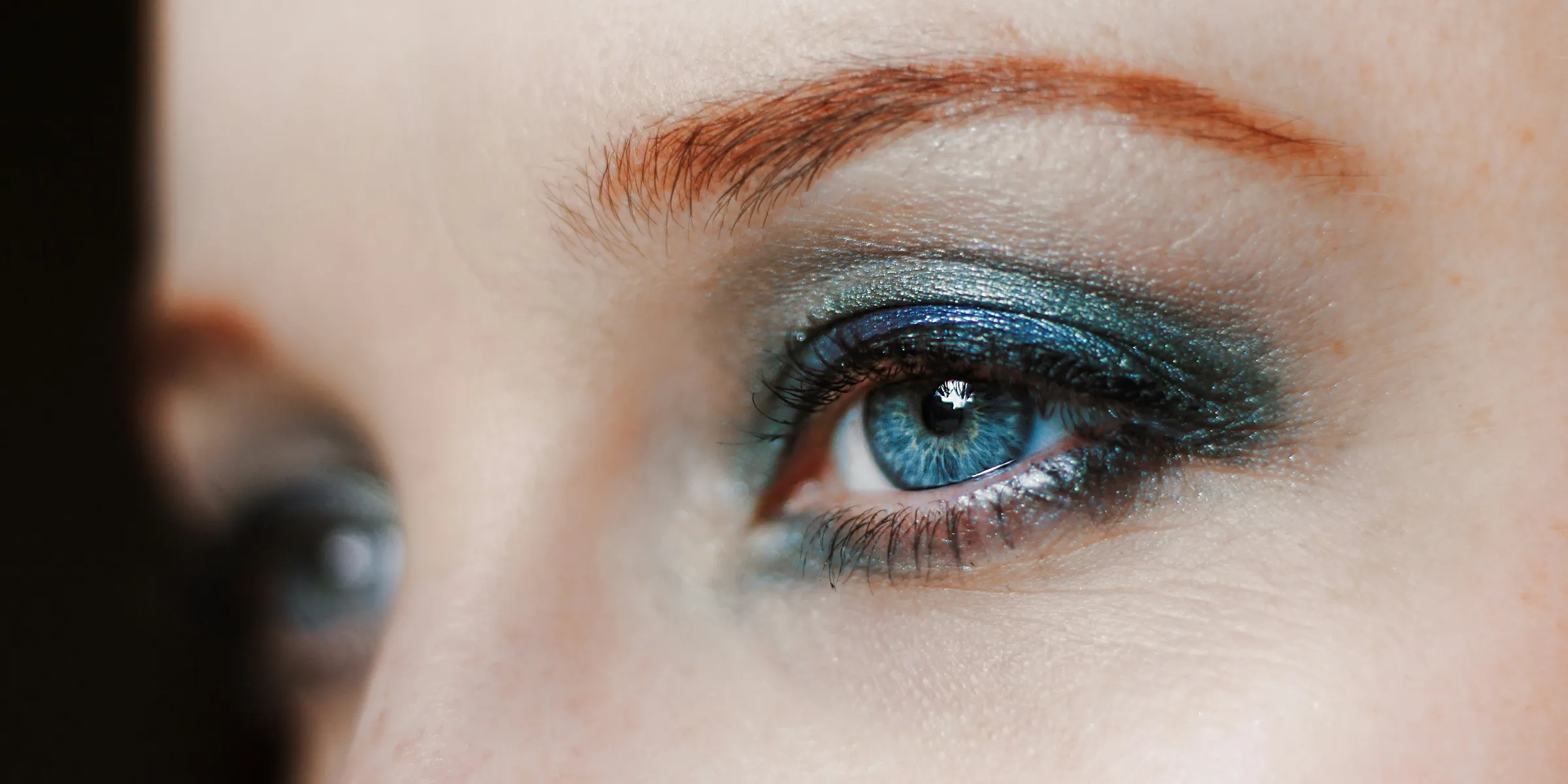 a close up of a woman's eye with blue eyeshadow
