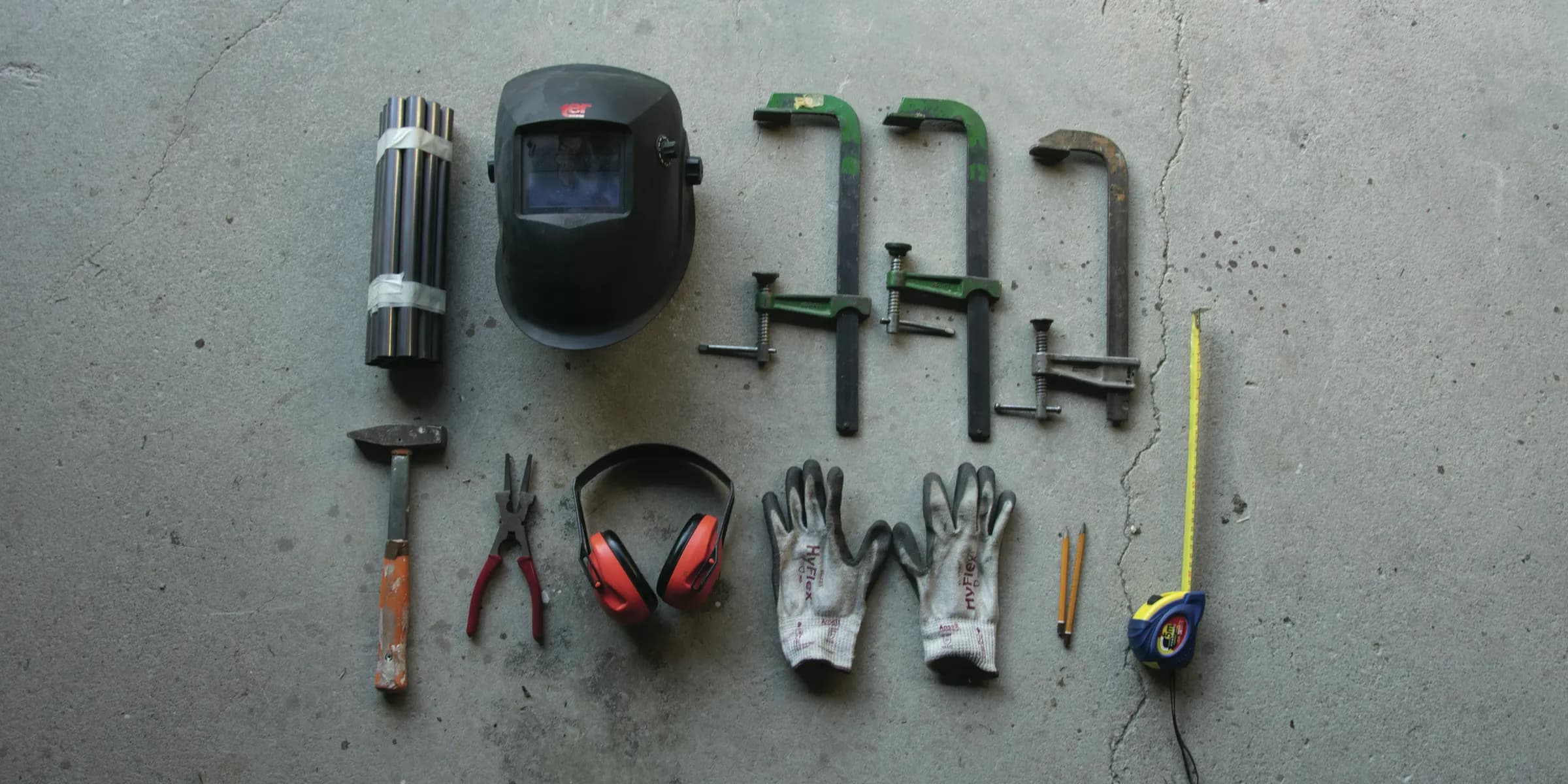 assorted hand tools on gray concrete floor