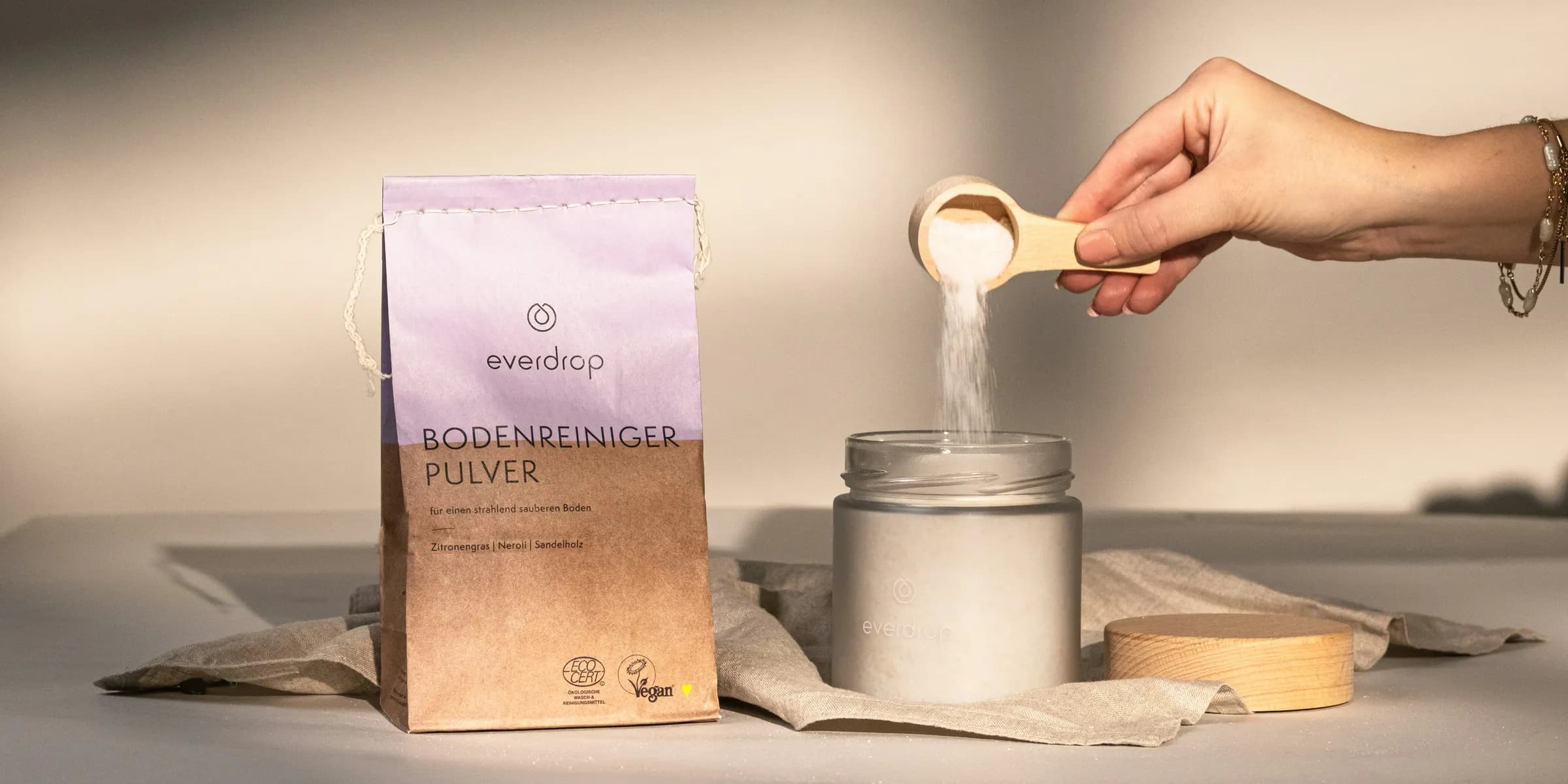 a person holding a spoon over a jar of food