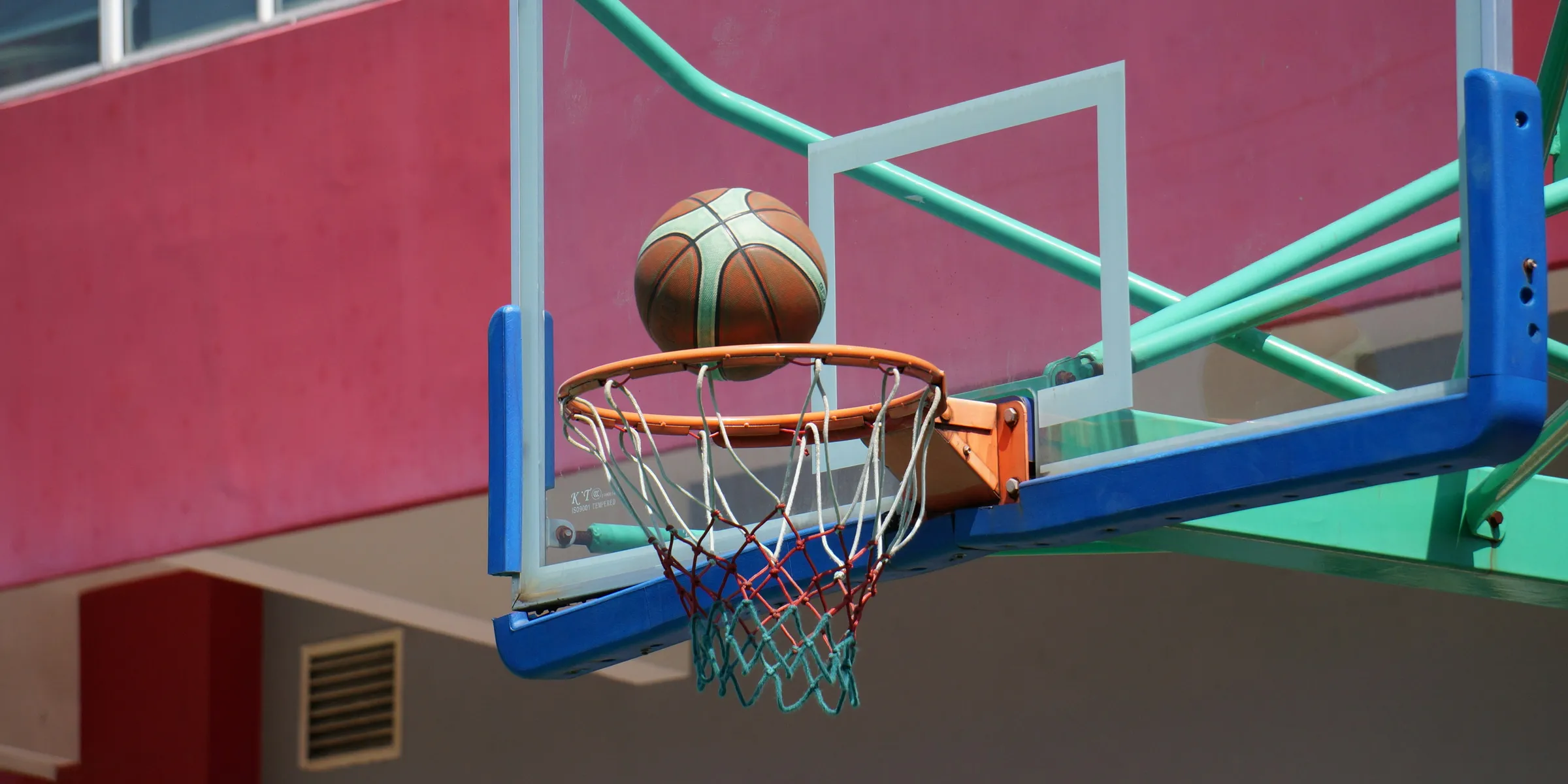 a basketball going through the hoop of a basketball court