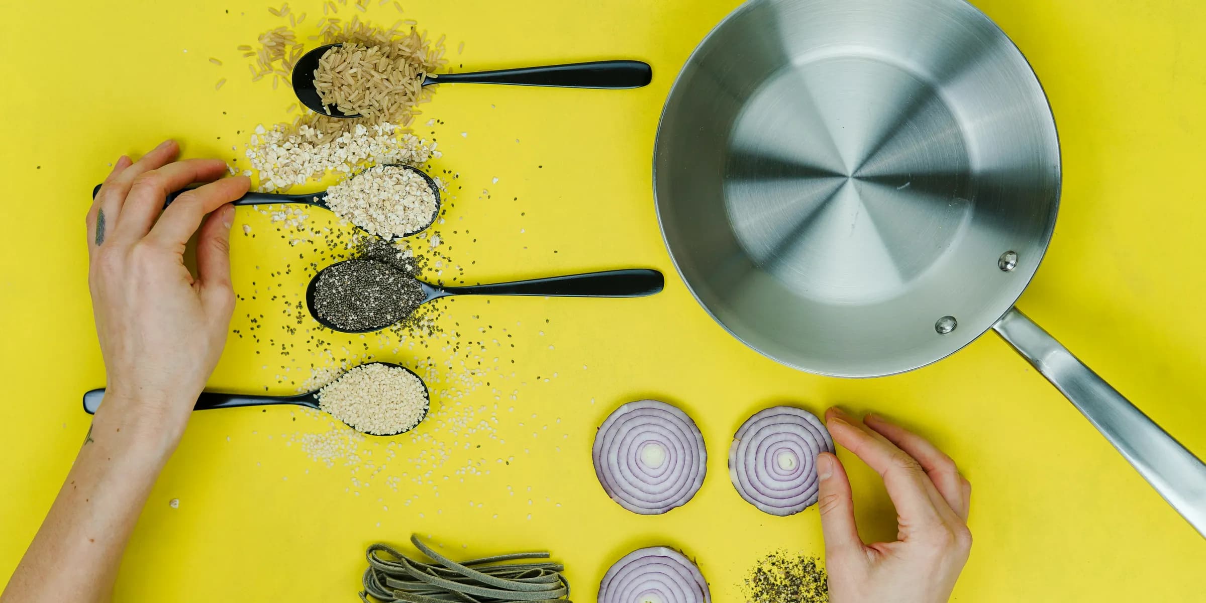 flat lay photography of saute skillet beside spoon of spices and vegetables