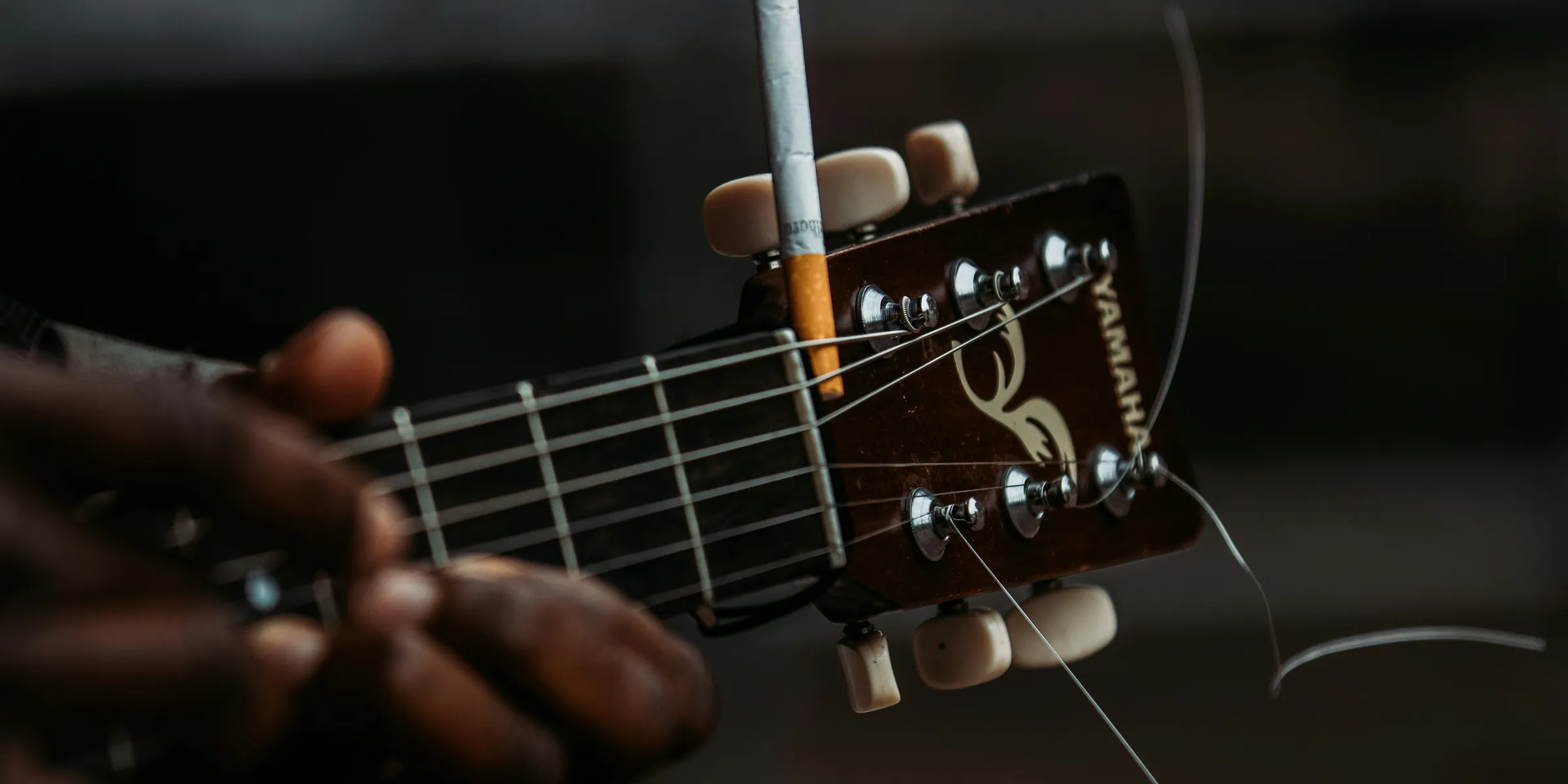 person playing brown acoustic guitar