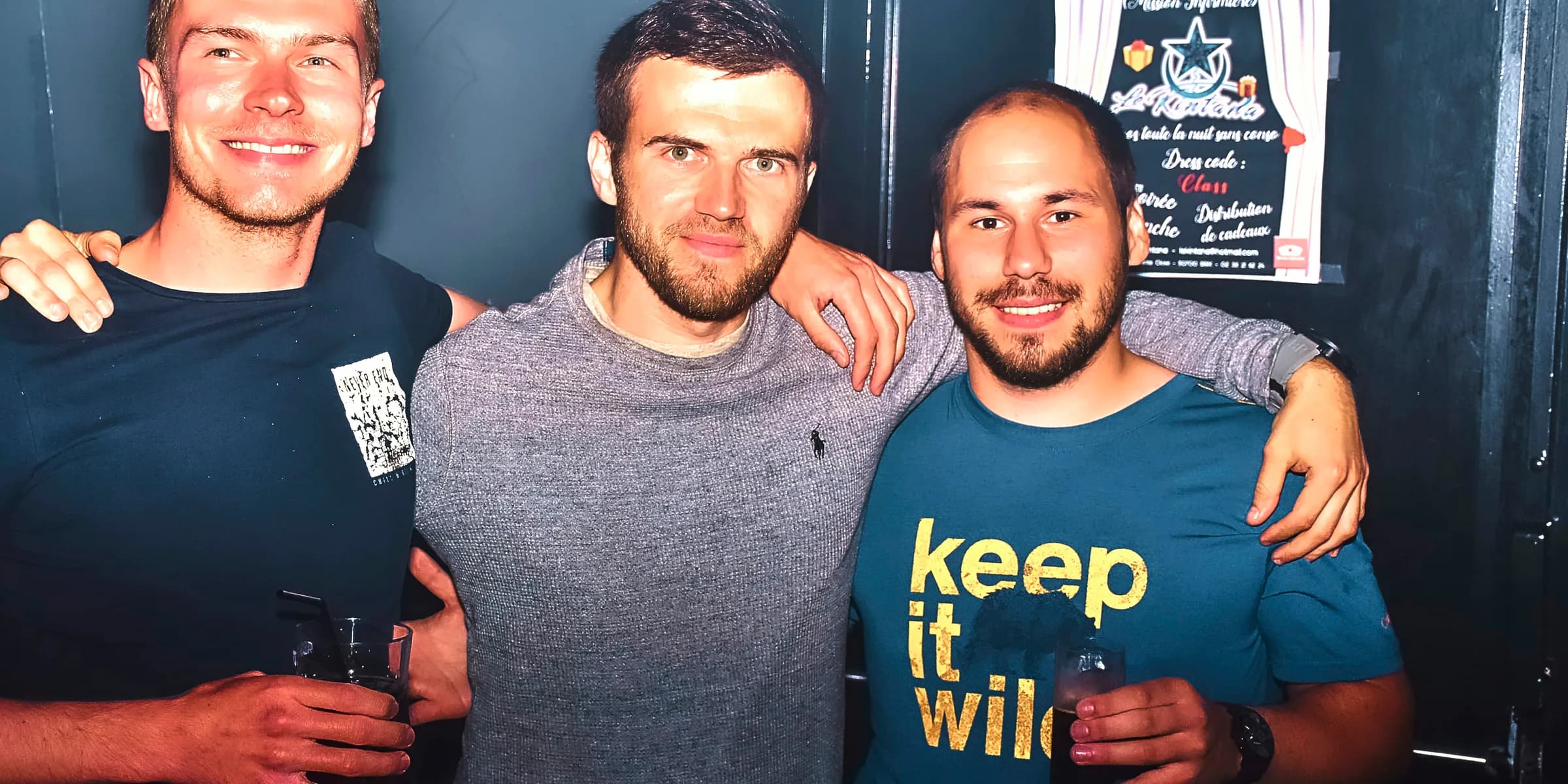 Three men smiling with arms around each other.