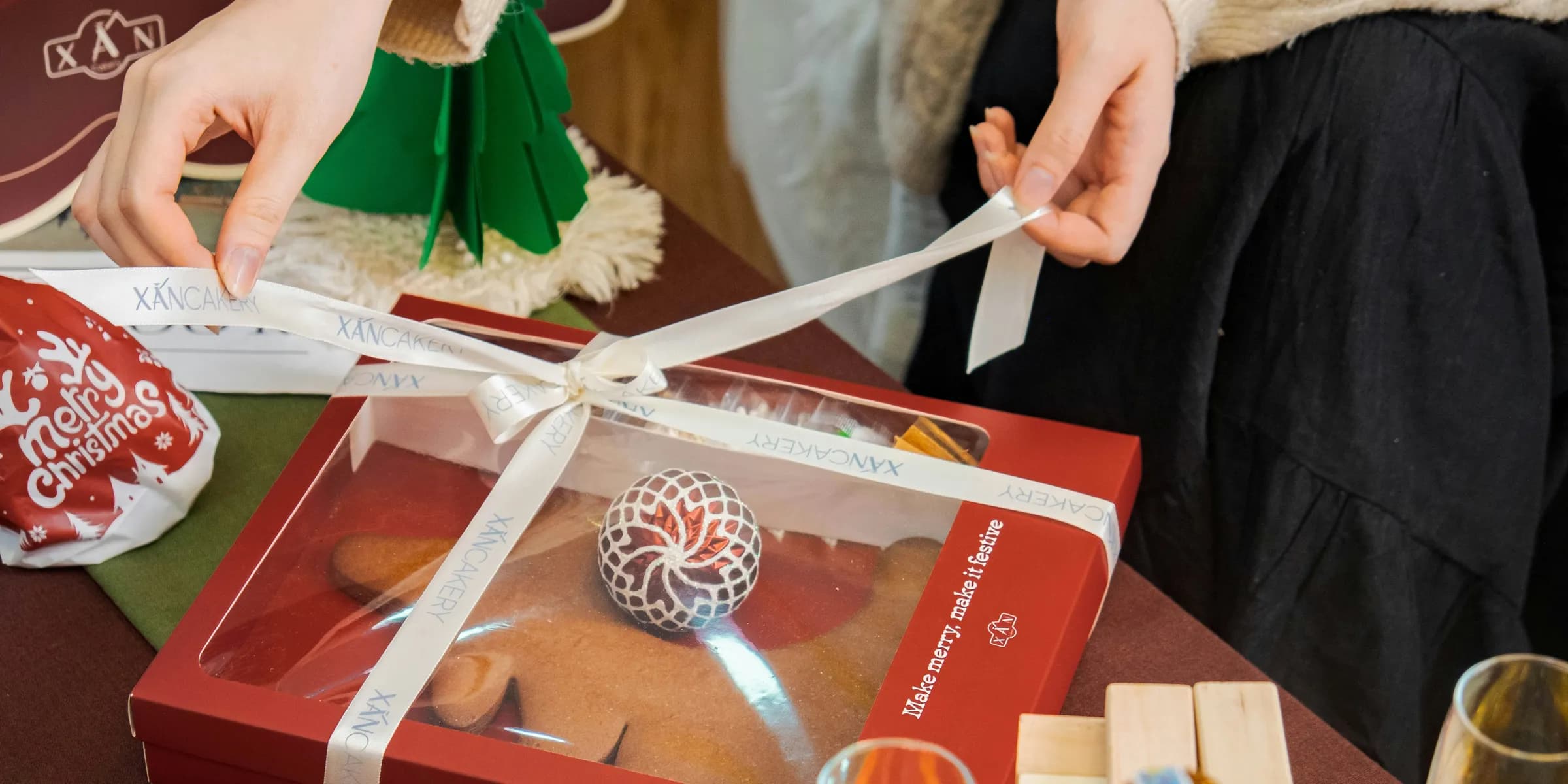 a person is wrapping a box of cookies on a table