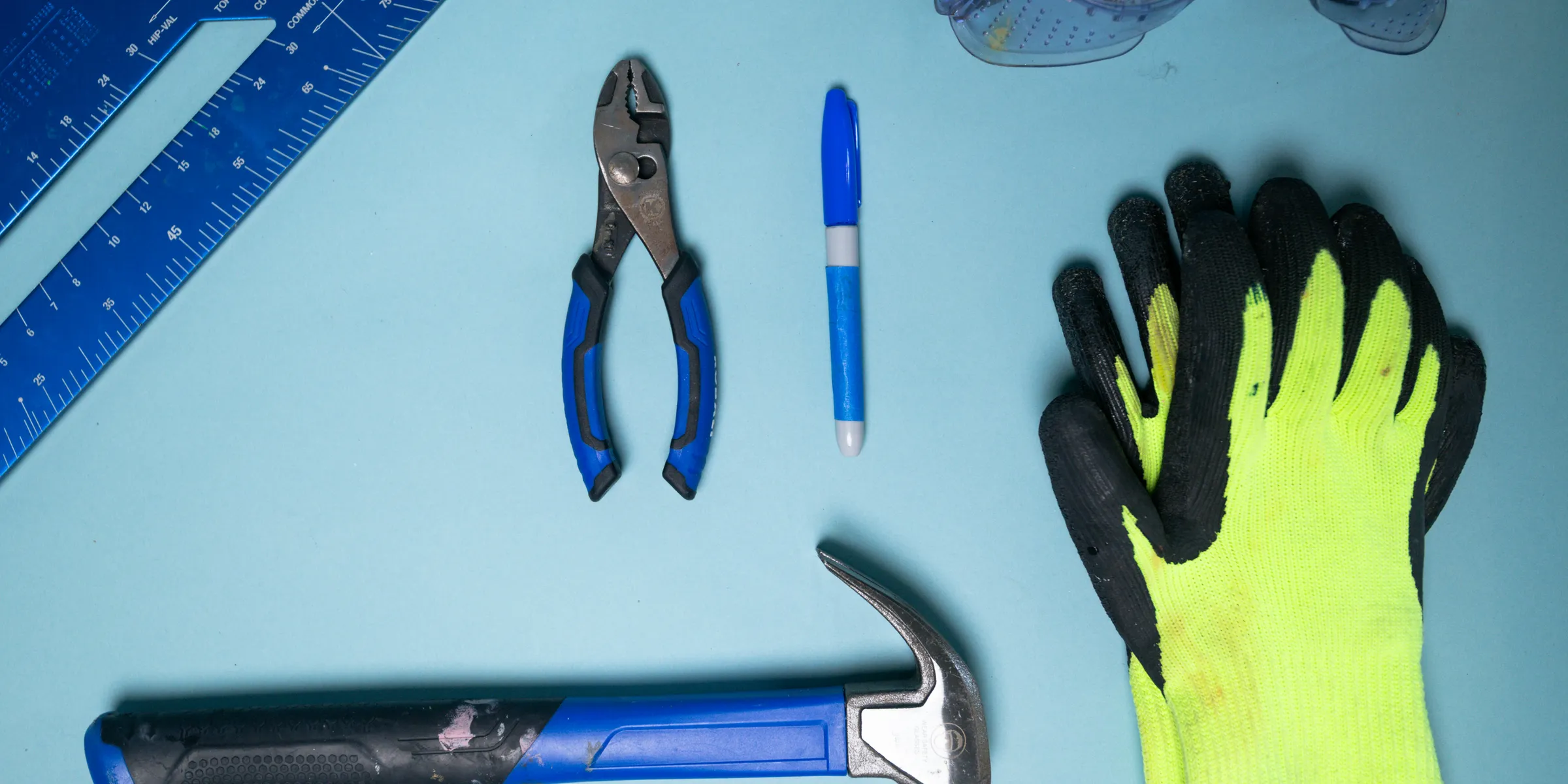 Tools including hammer, pliers, marker, gloves, and safety glasses.