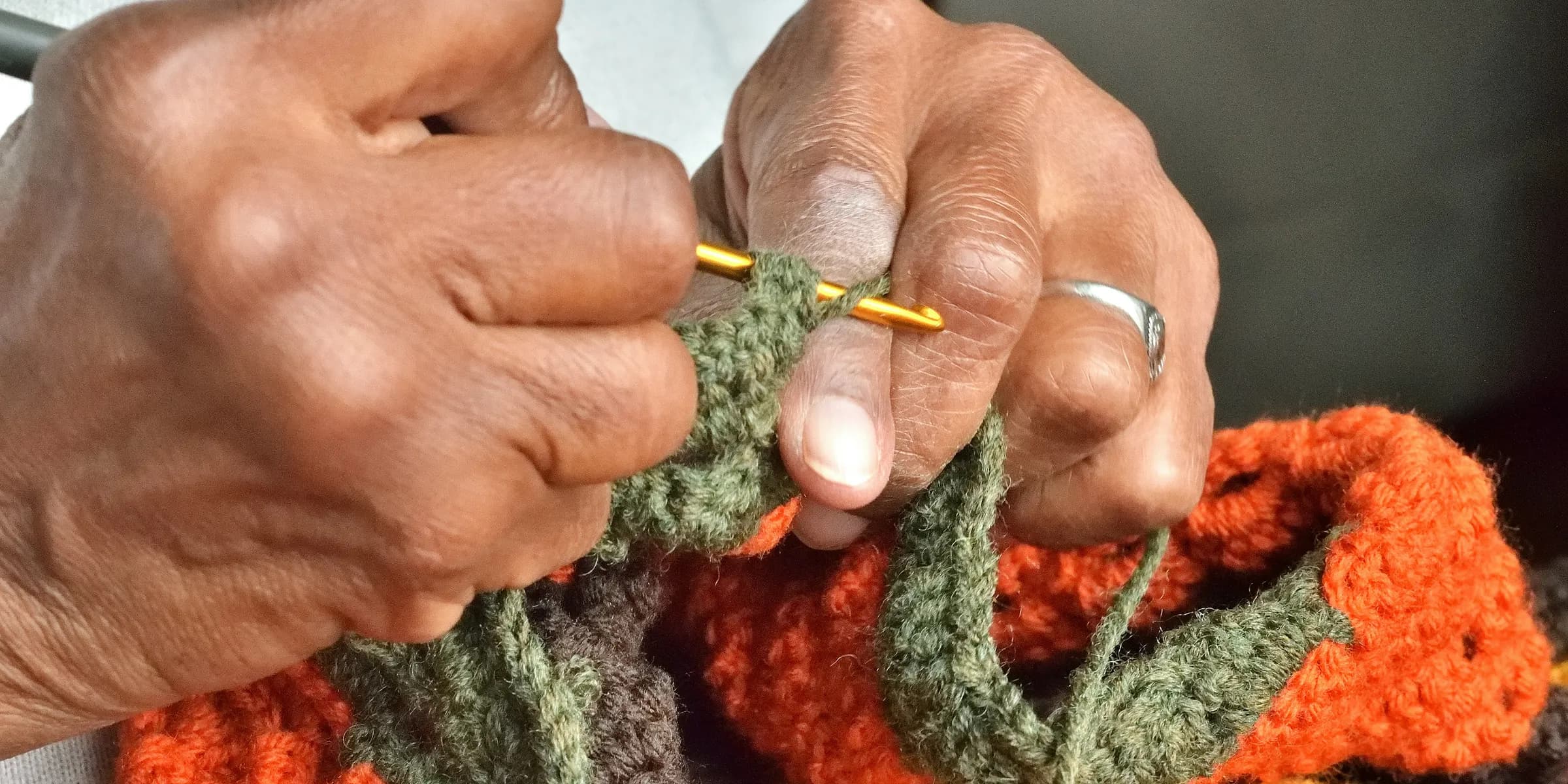 A person holding a crochet hook in their hands