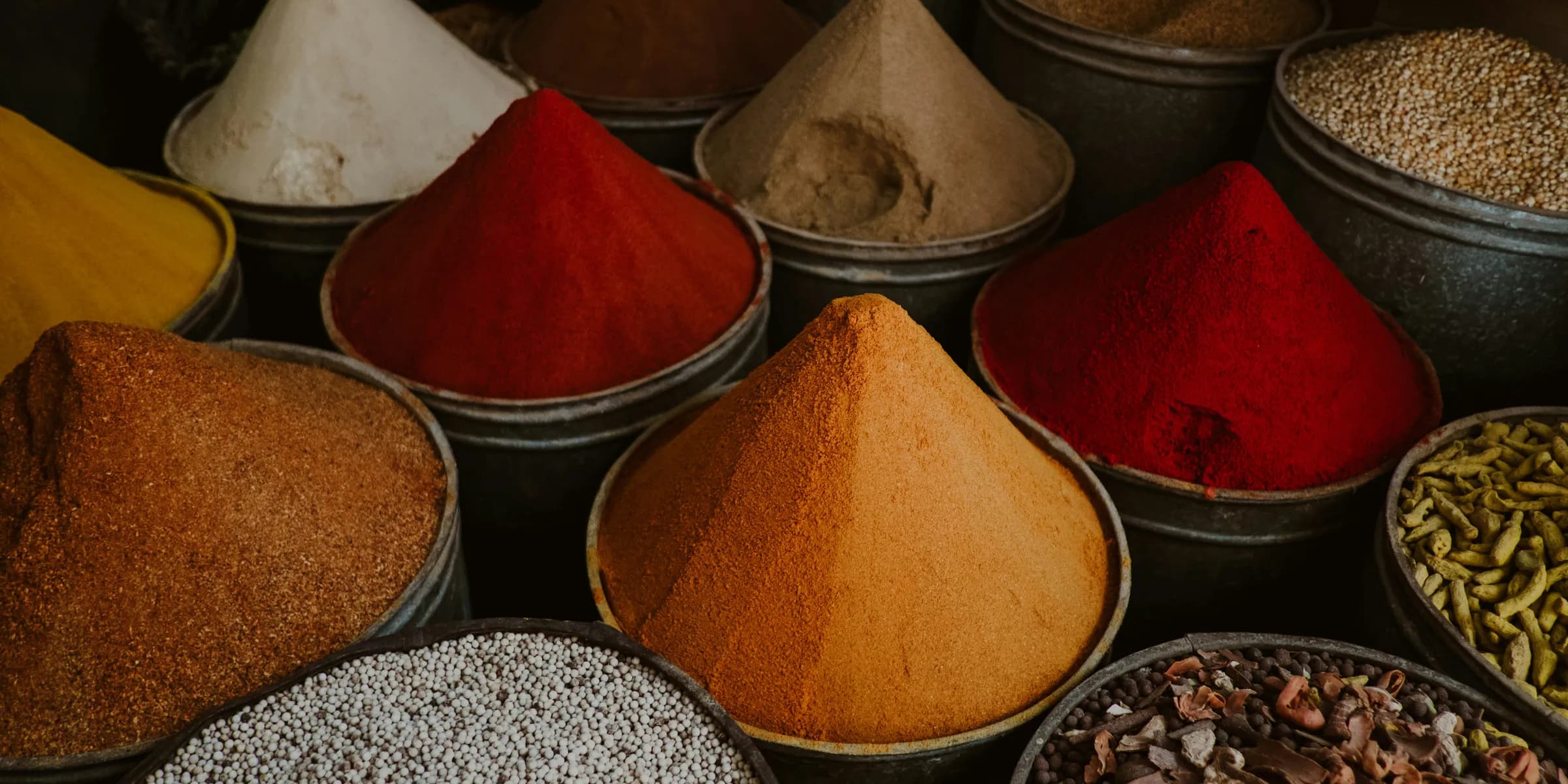 a variety of different colored spices in bowls