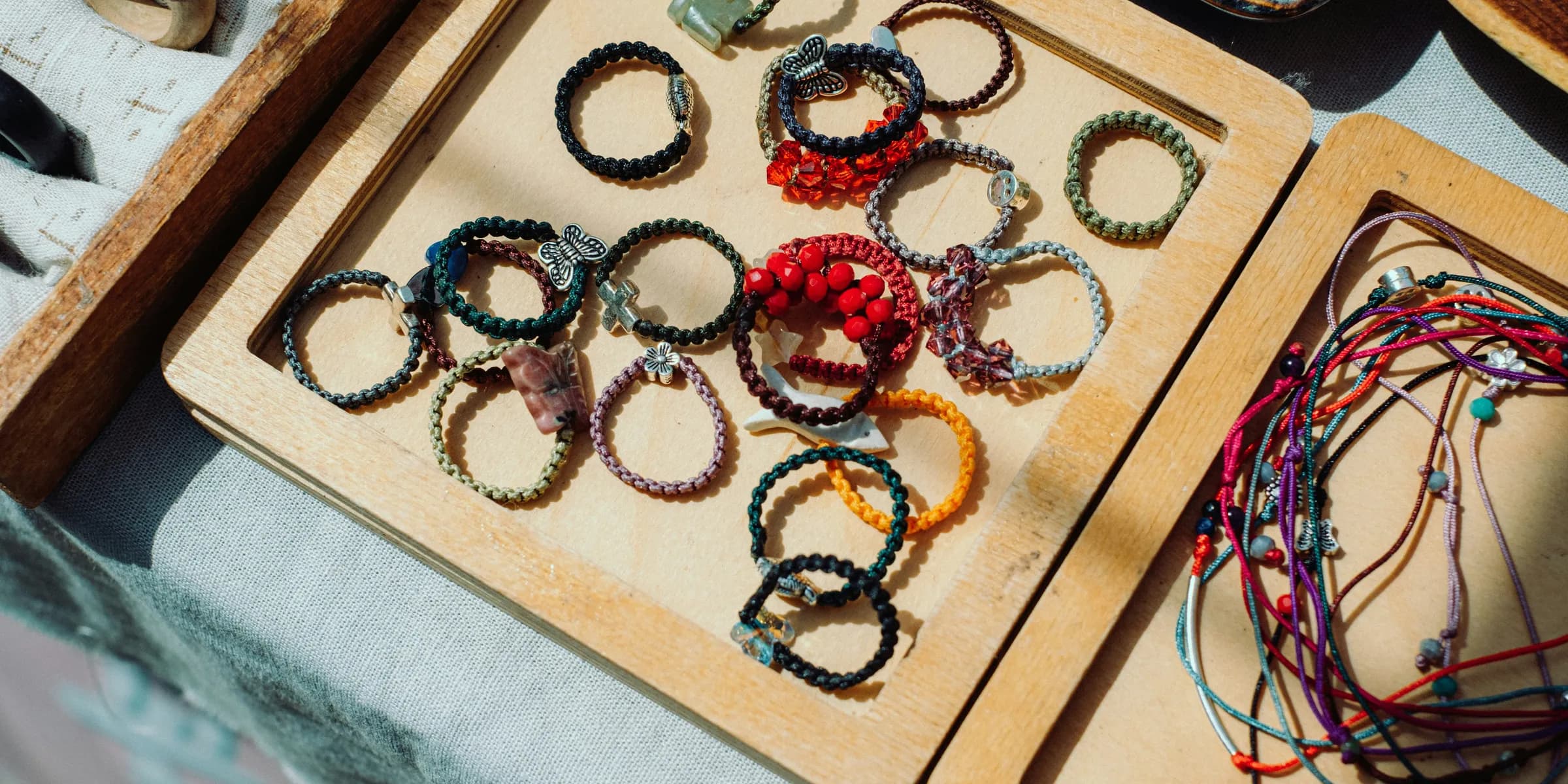 a wooden tray filled with lots of bracelets on top of a table