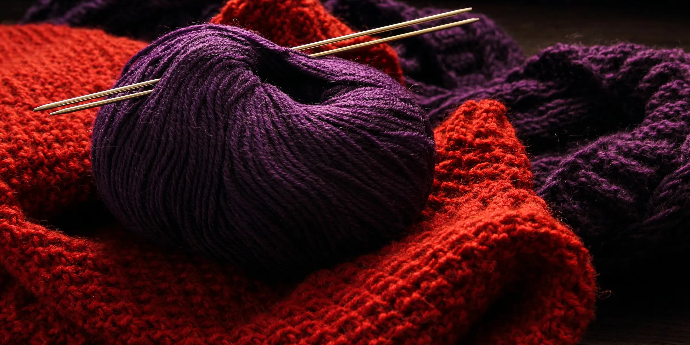 a close up of a ball of yarn and knitting needles