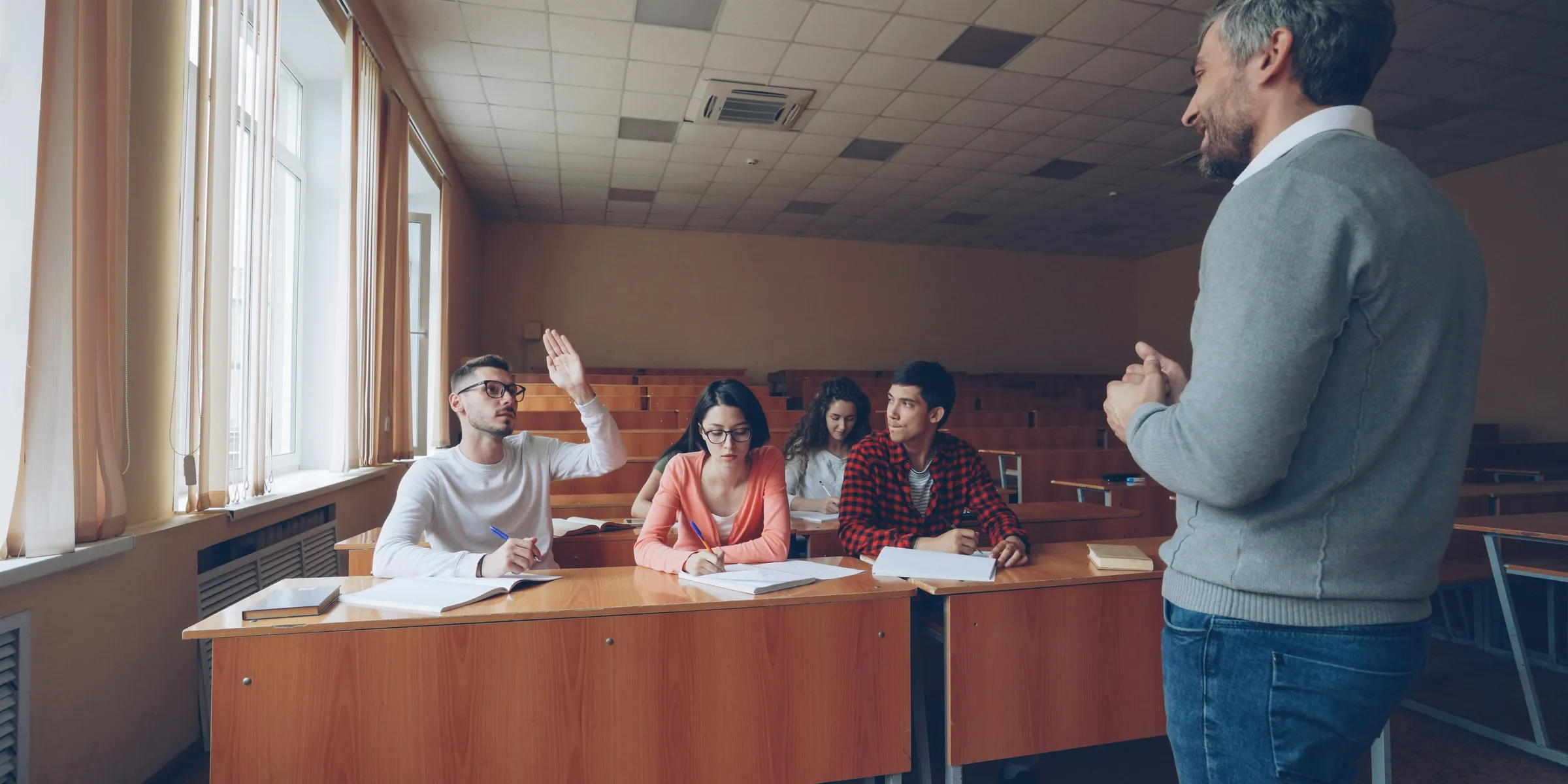 Teacher interacting with students in a classroom setting.