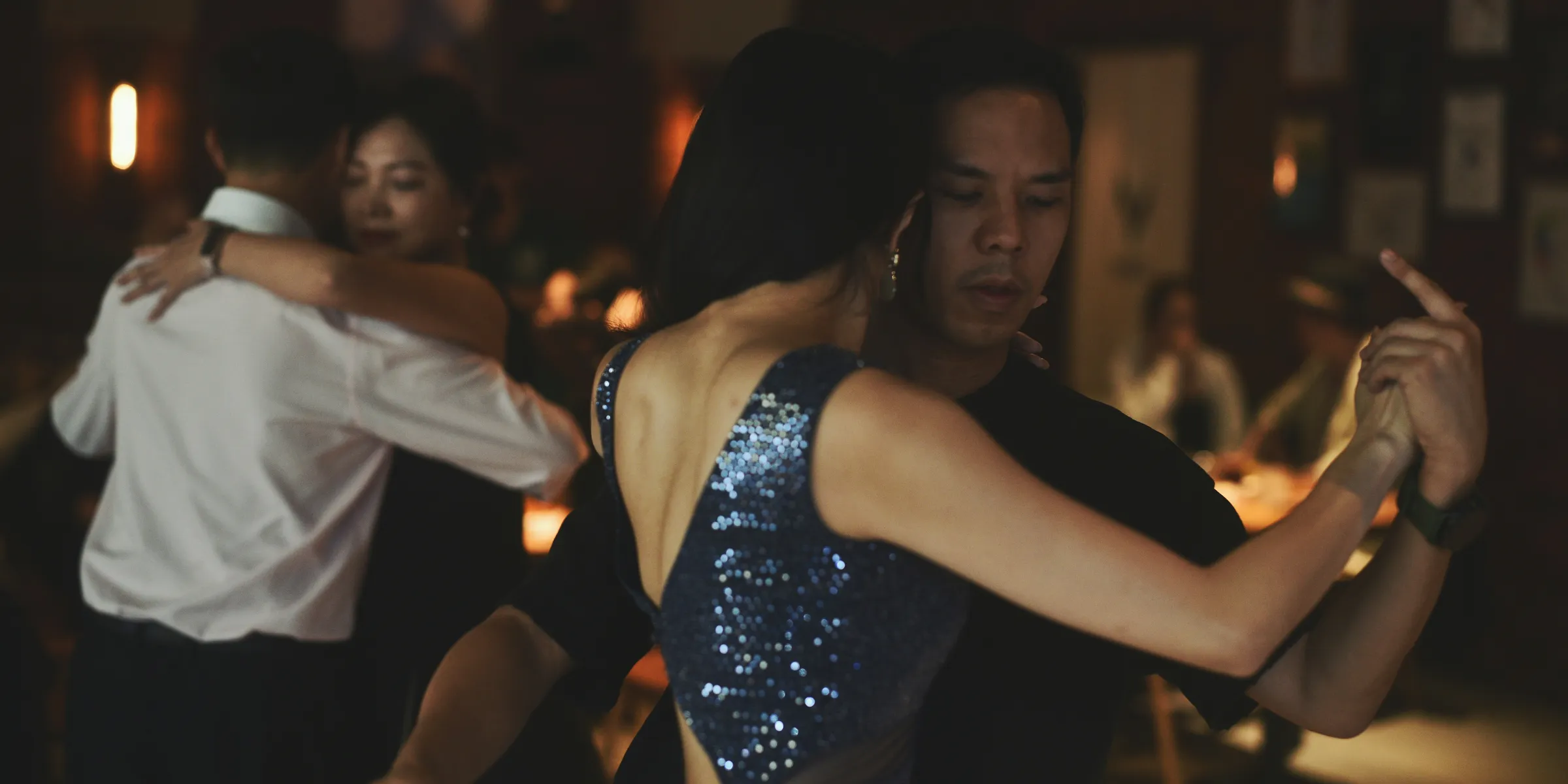 Couples dancing tango in a dimly lit ballroom