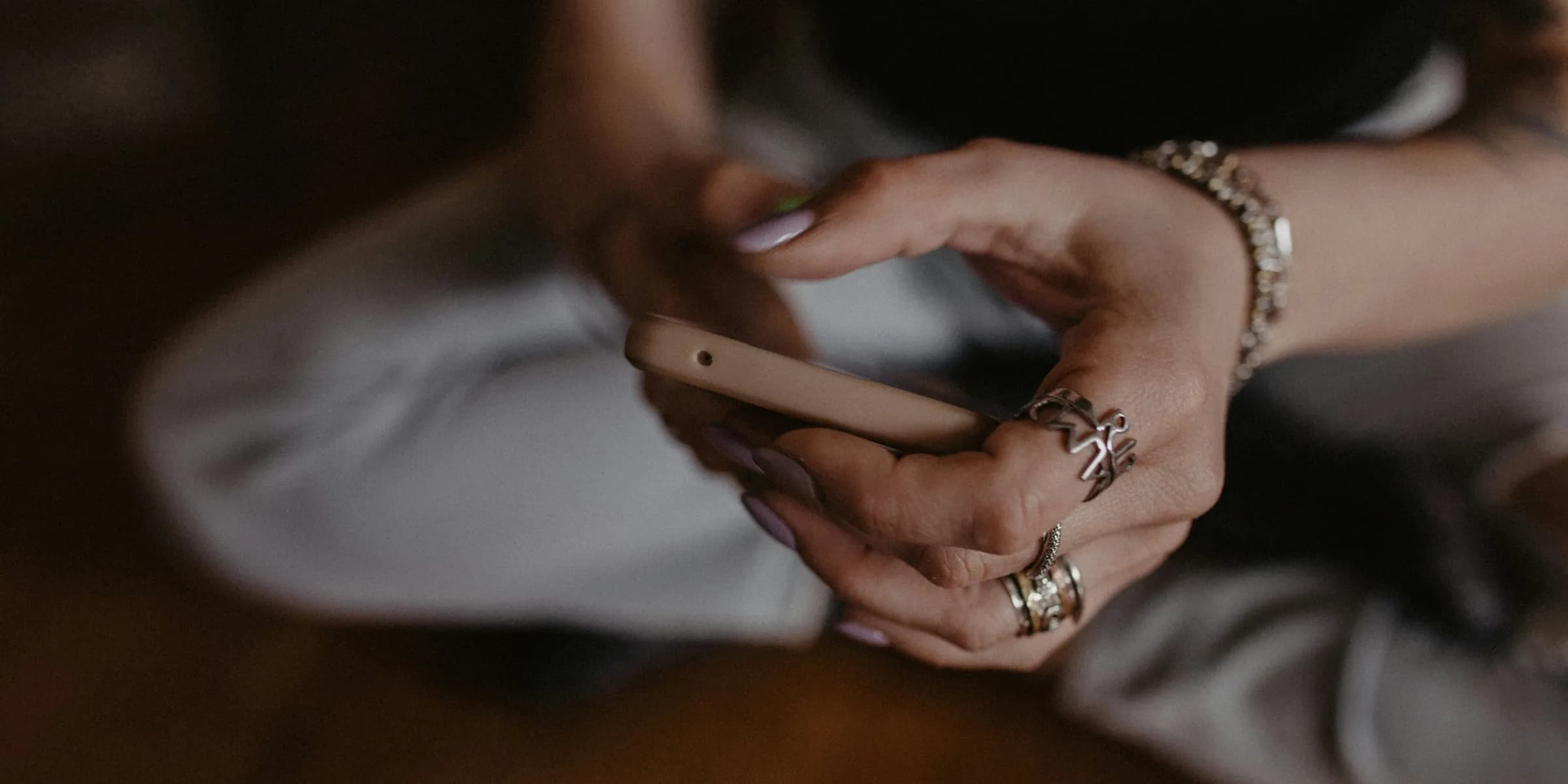 a woman sitting on the floor holding a cell phone