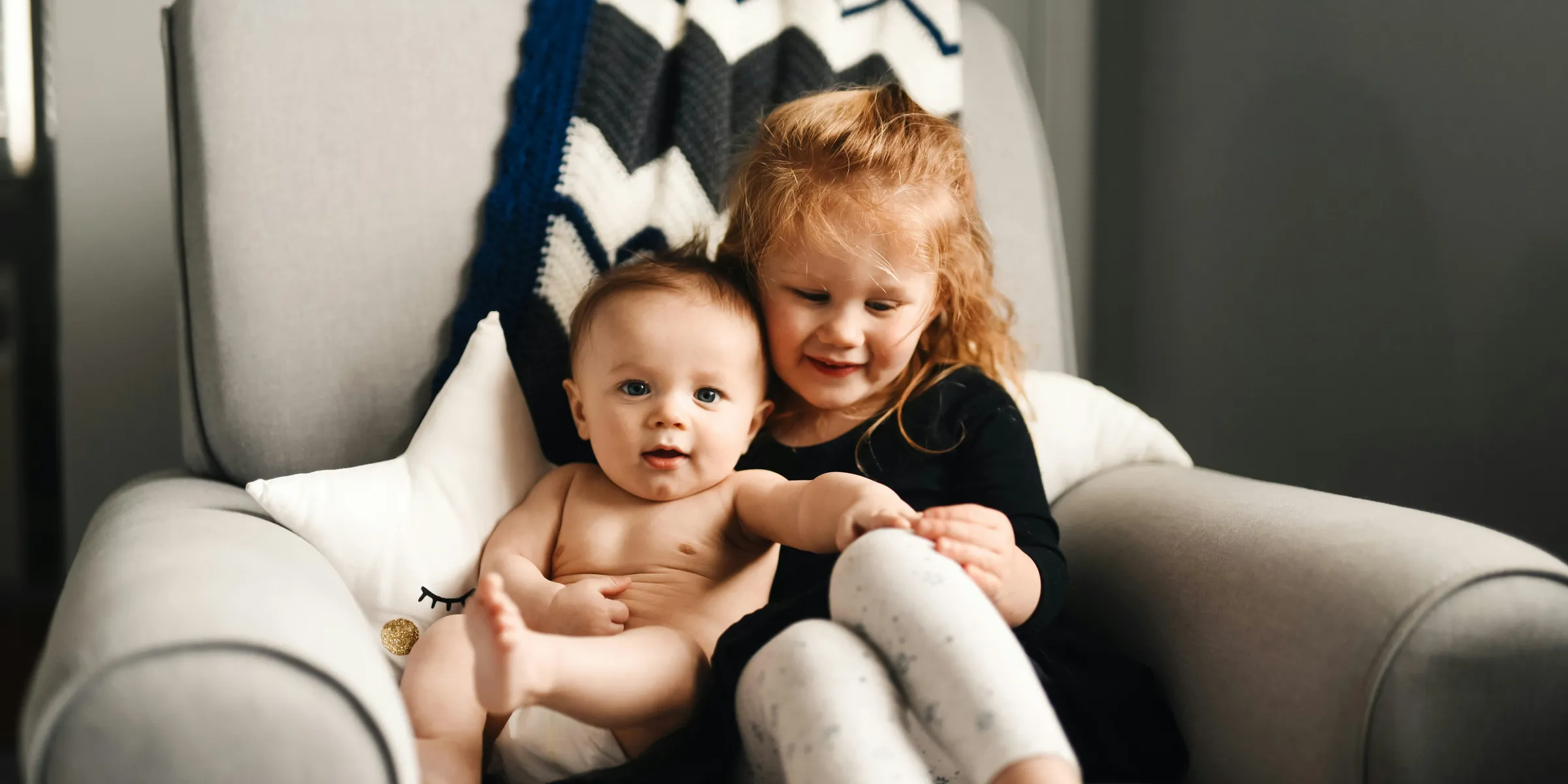 woman in black long sleeve shirt carrying baby in black onesie