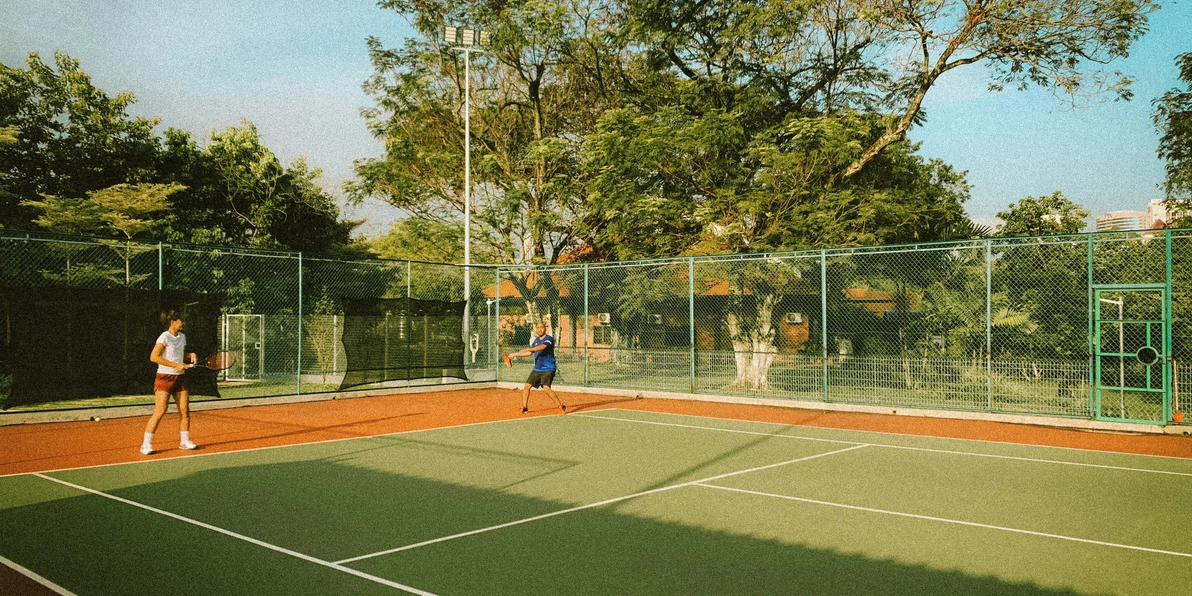 two people playing tennis on a tennis court