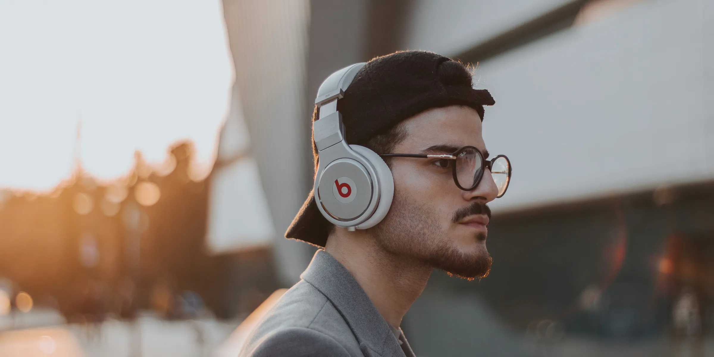 shallow focus photography of man wearing Beats wireless headphones