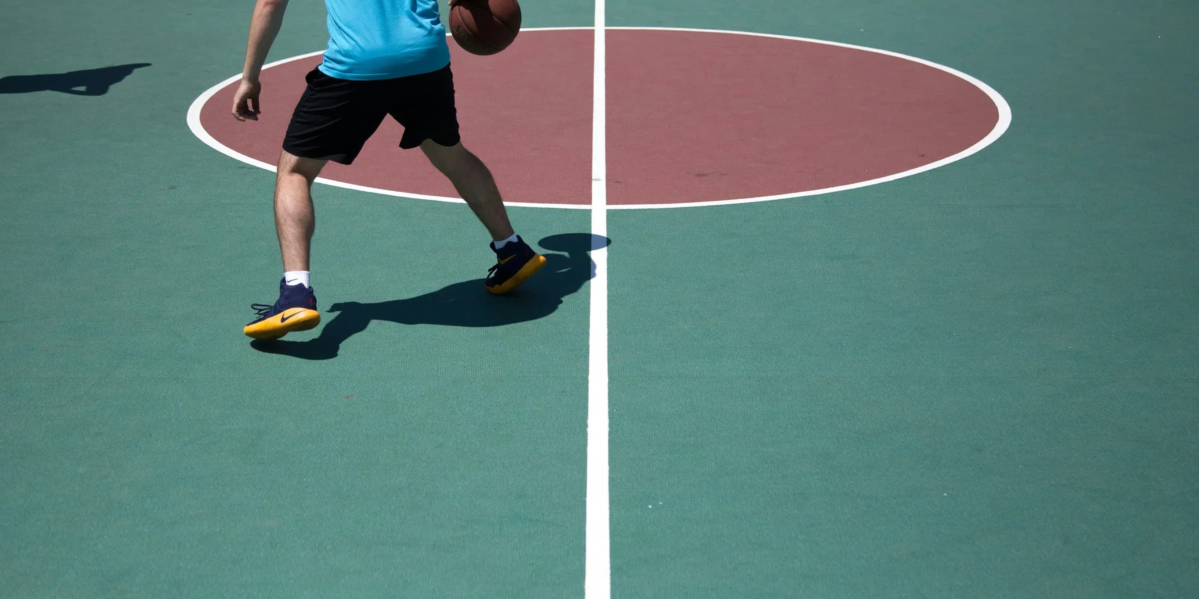 man dribbling ball on court