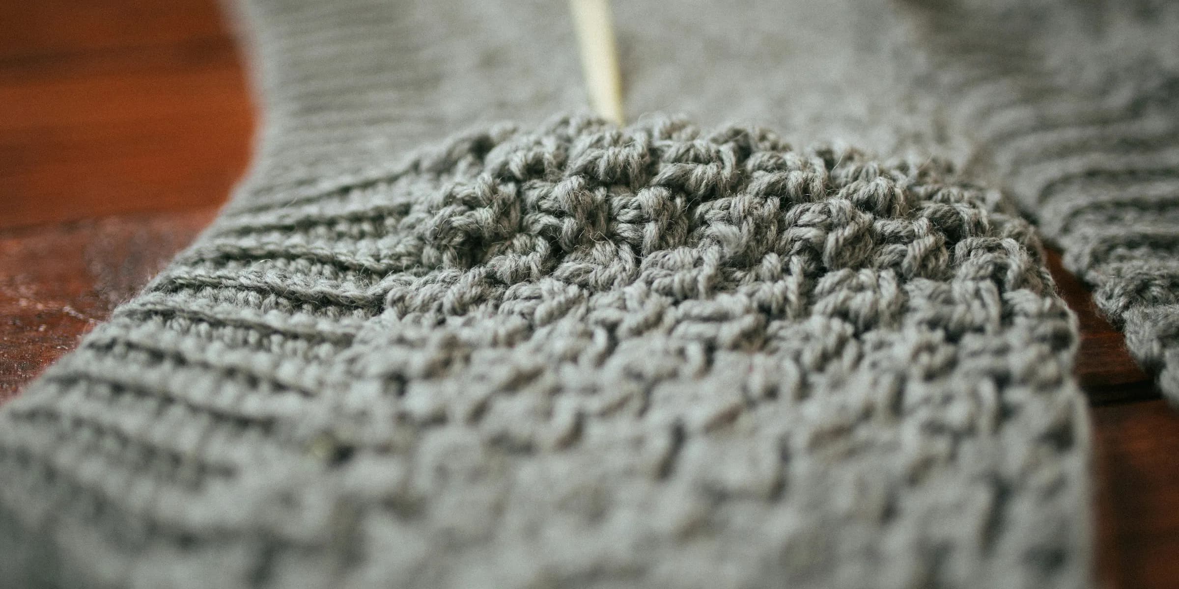 person holding gray knit textile