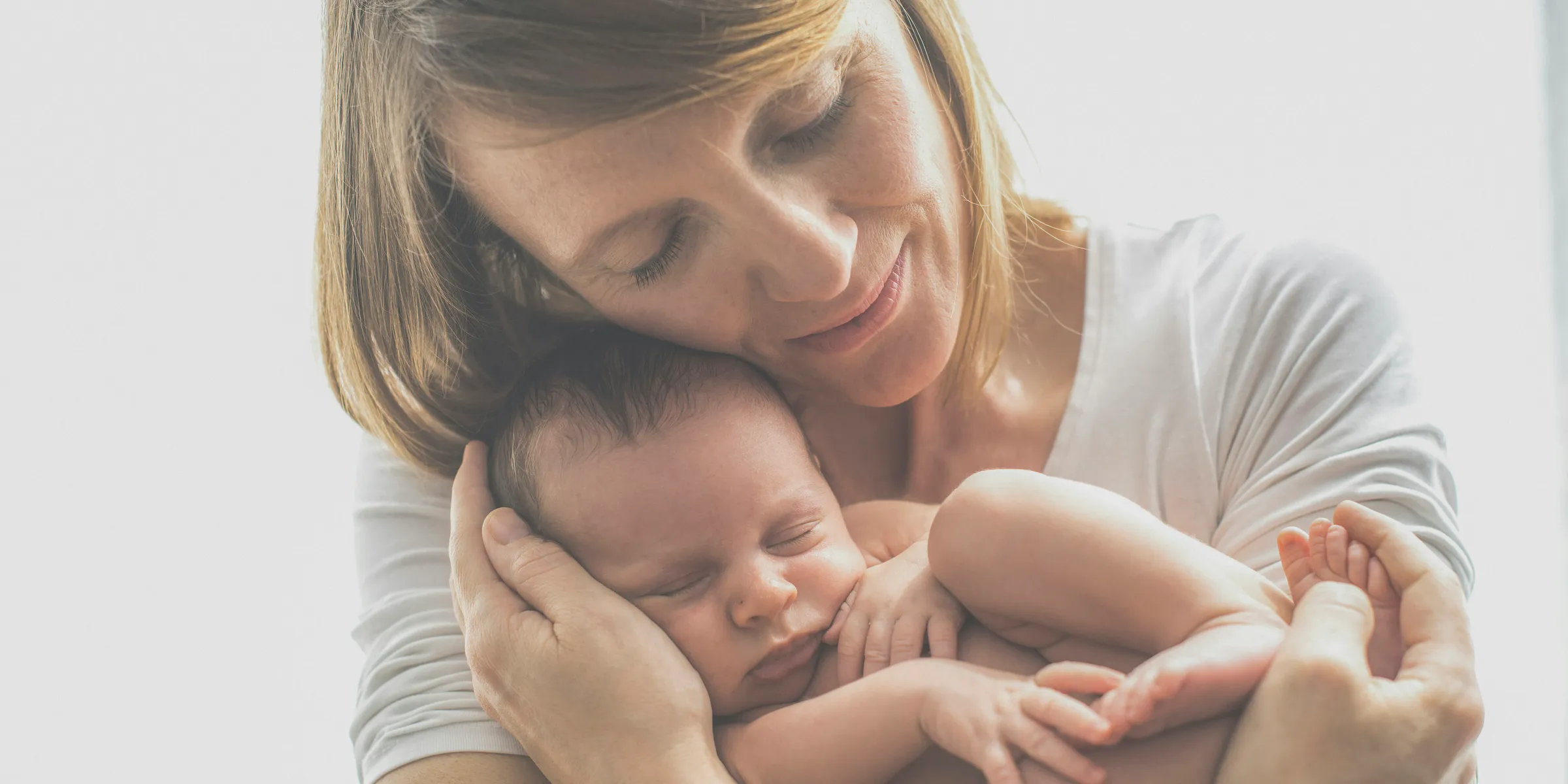 woman in white crew neck t-shirt carrying baby