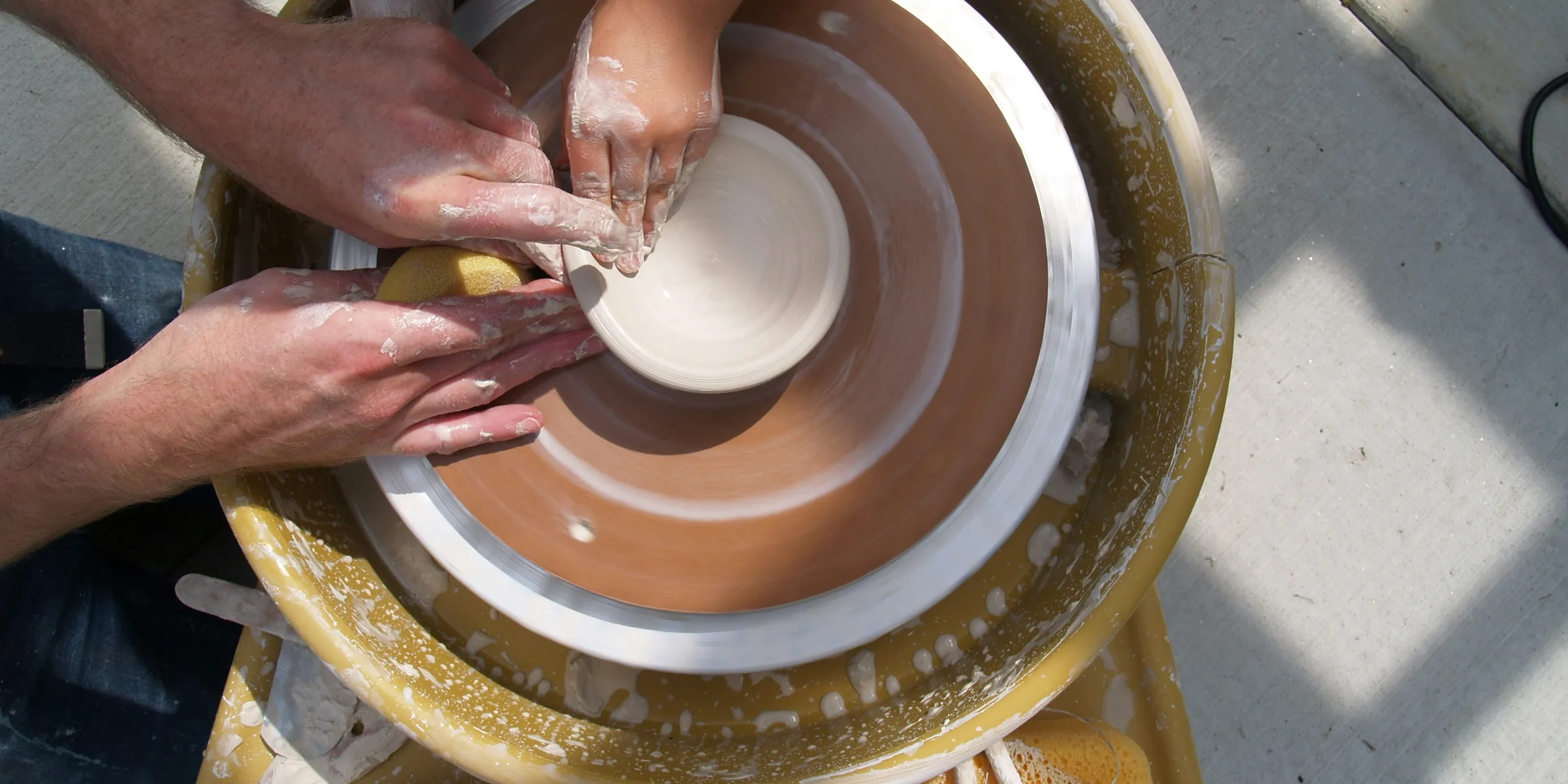 a group of people working on a pottery wheel