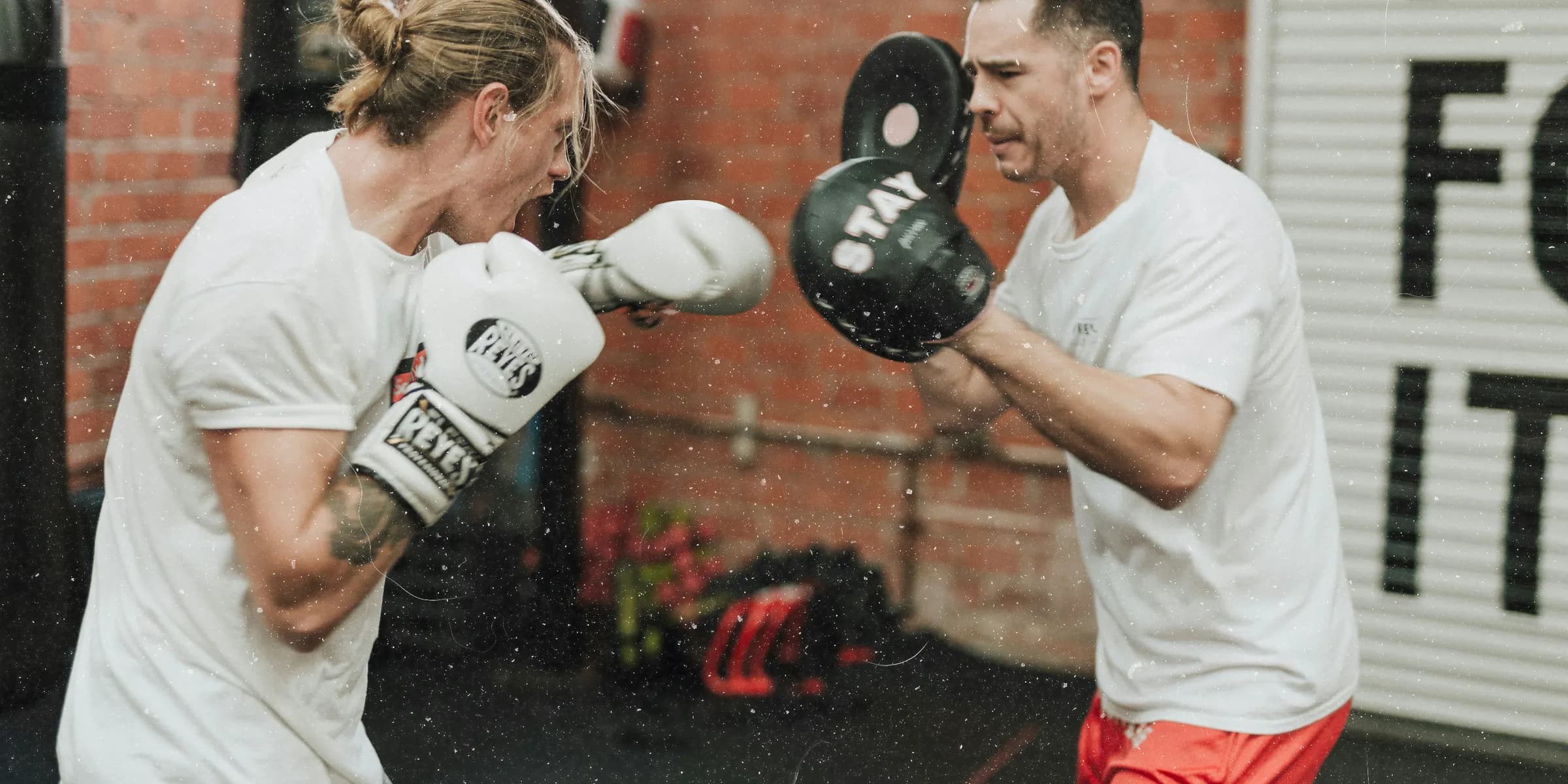 two men sparring inside boxing gym