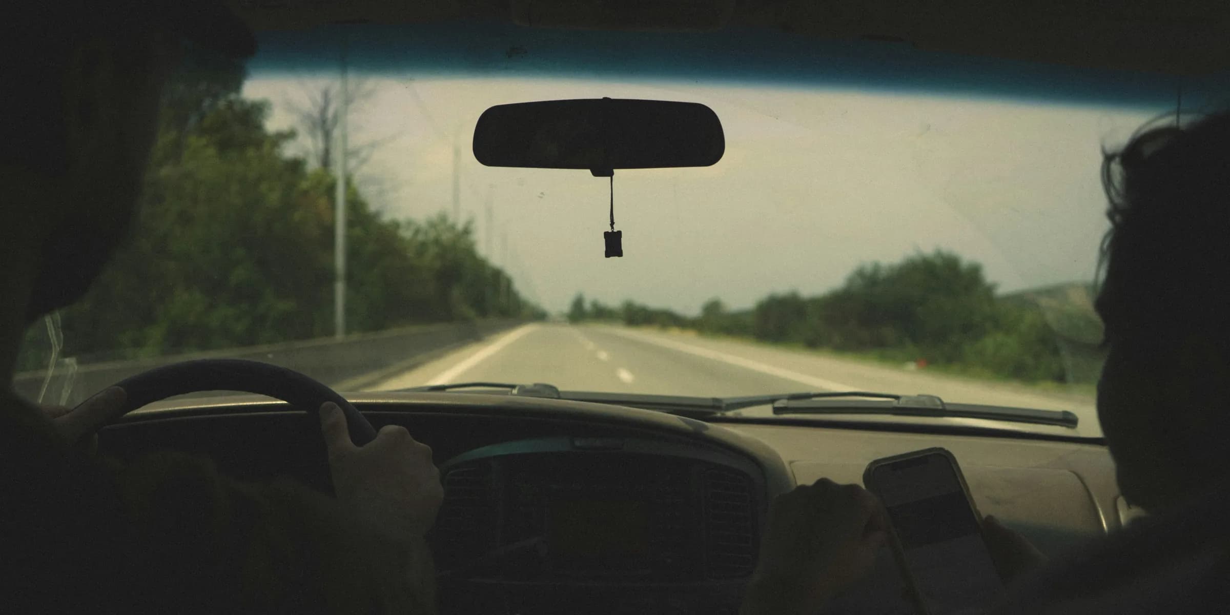 person driving car on road during daytime