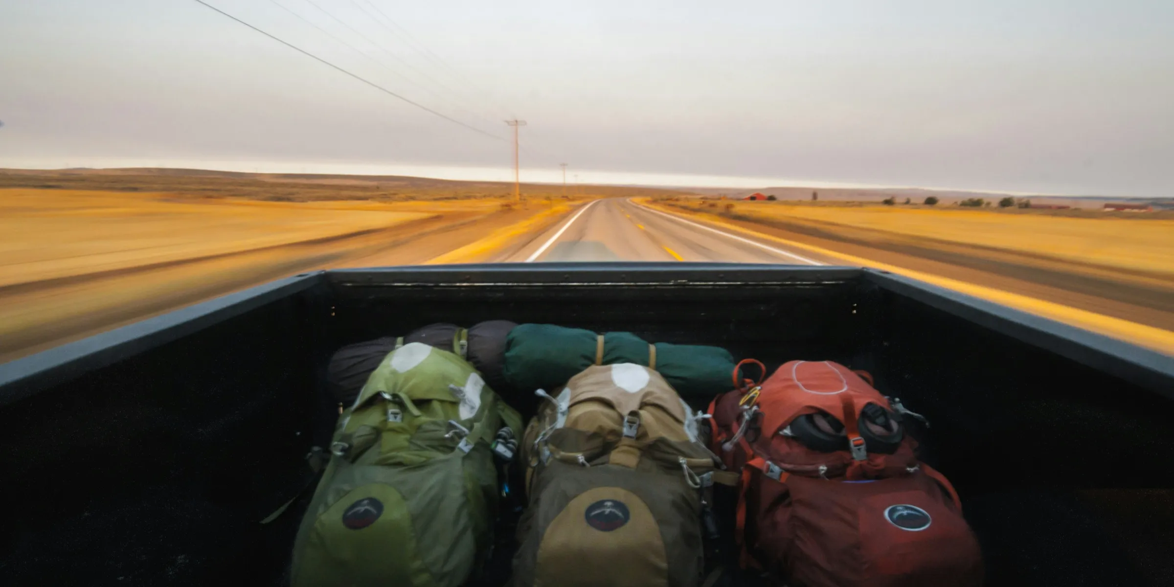 photography of several hiking backpacks in truck bed