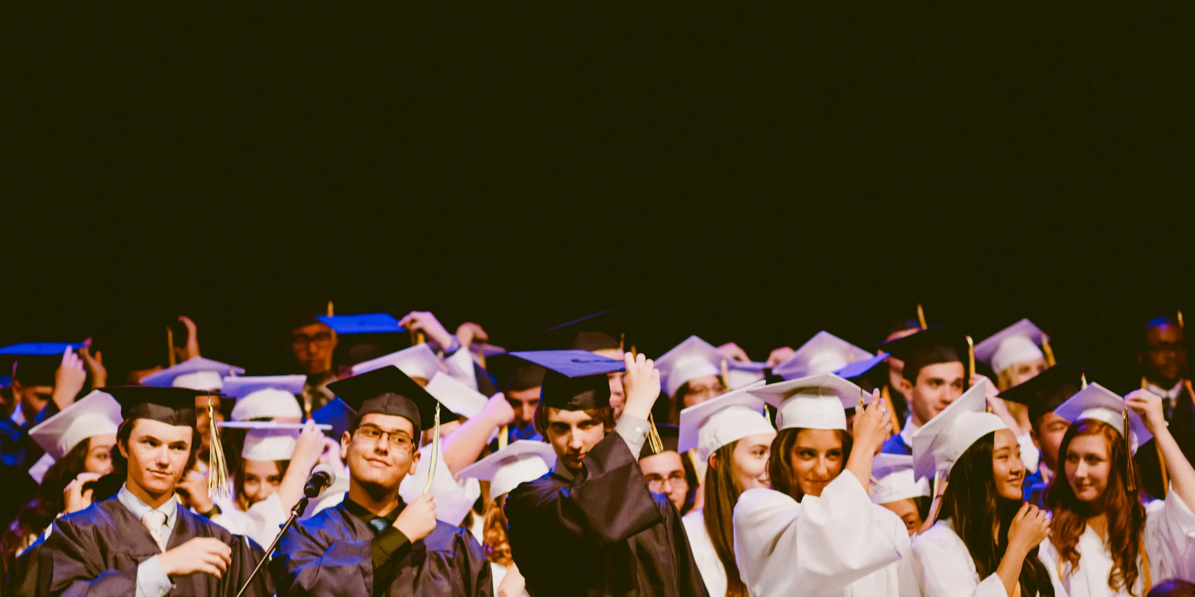 men and women wearing black and white graduation dress and mortar cap inside building