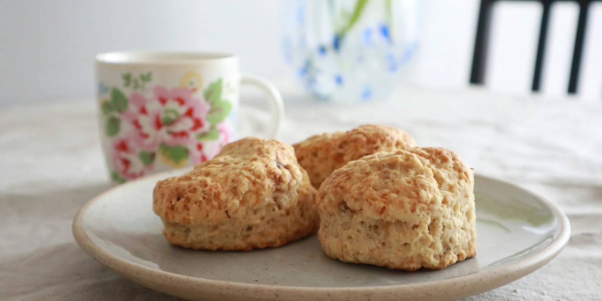 biscuits on a plate next to a cup of coffee