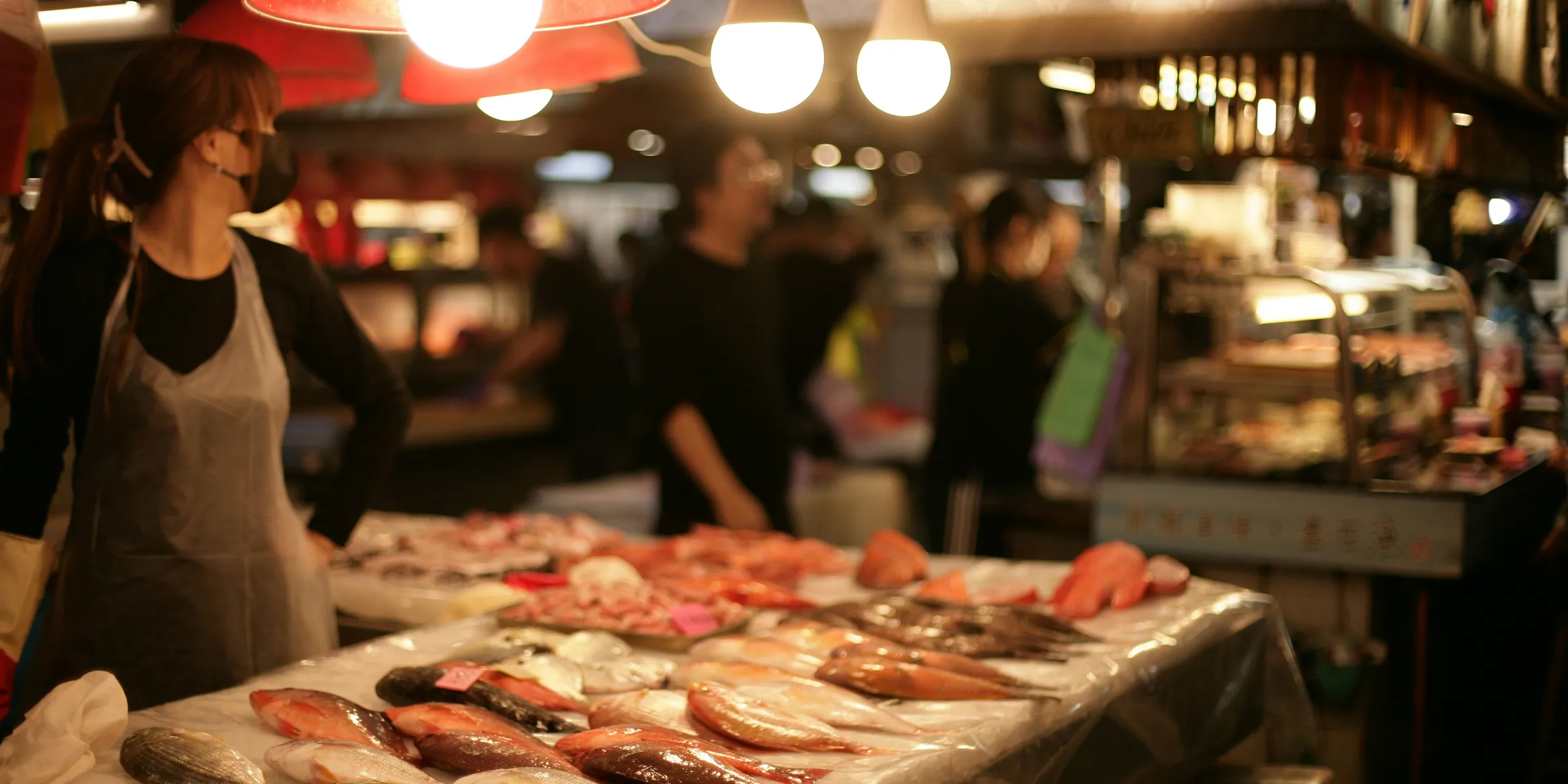 A woman standing in front of a table filled with fish