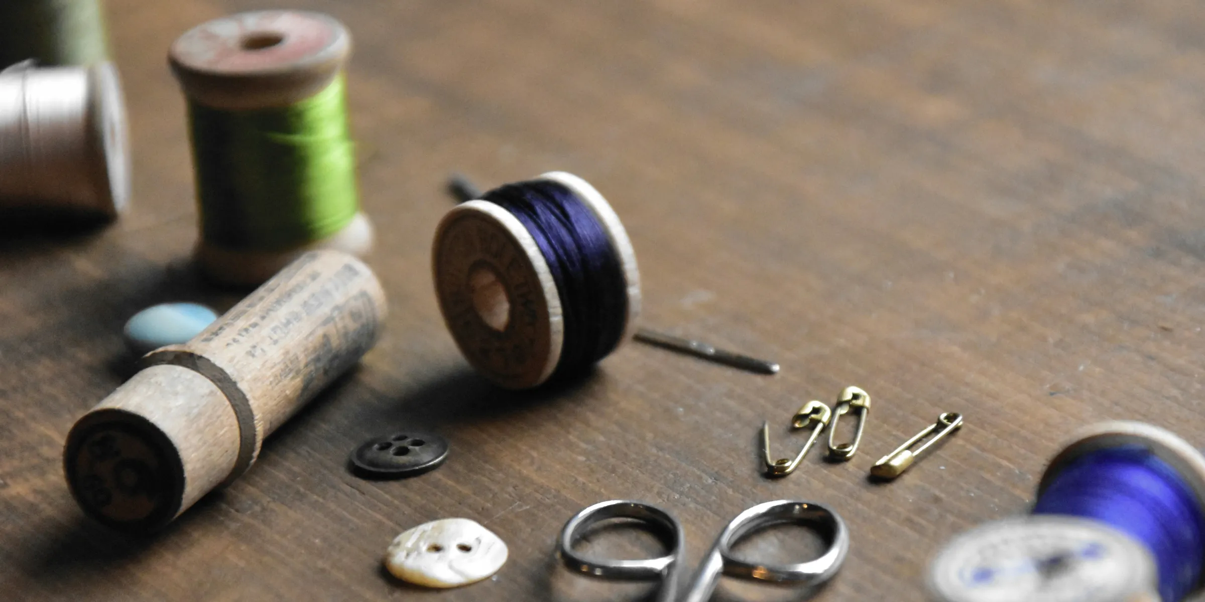 a wooden table topped with lots of sewing supplies