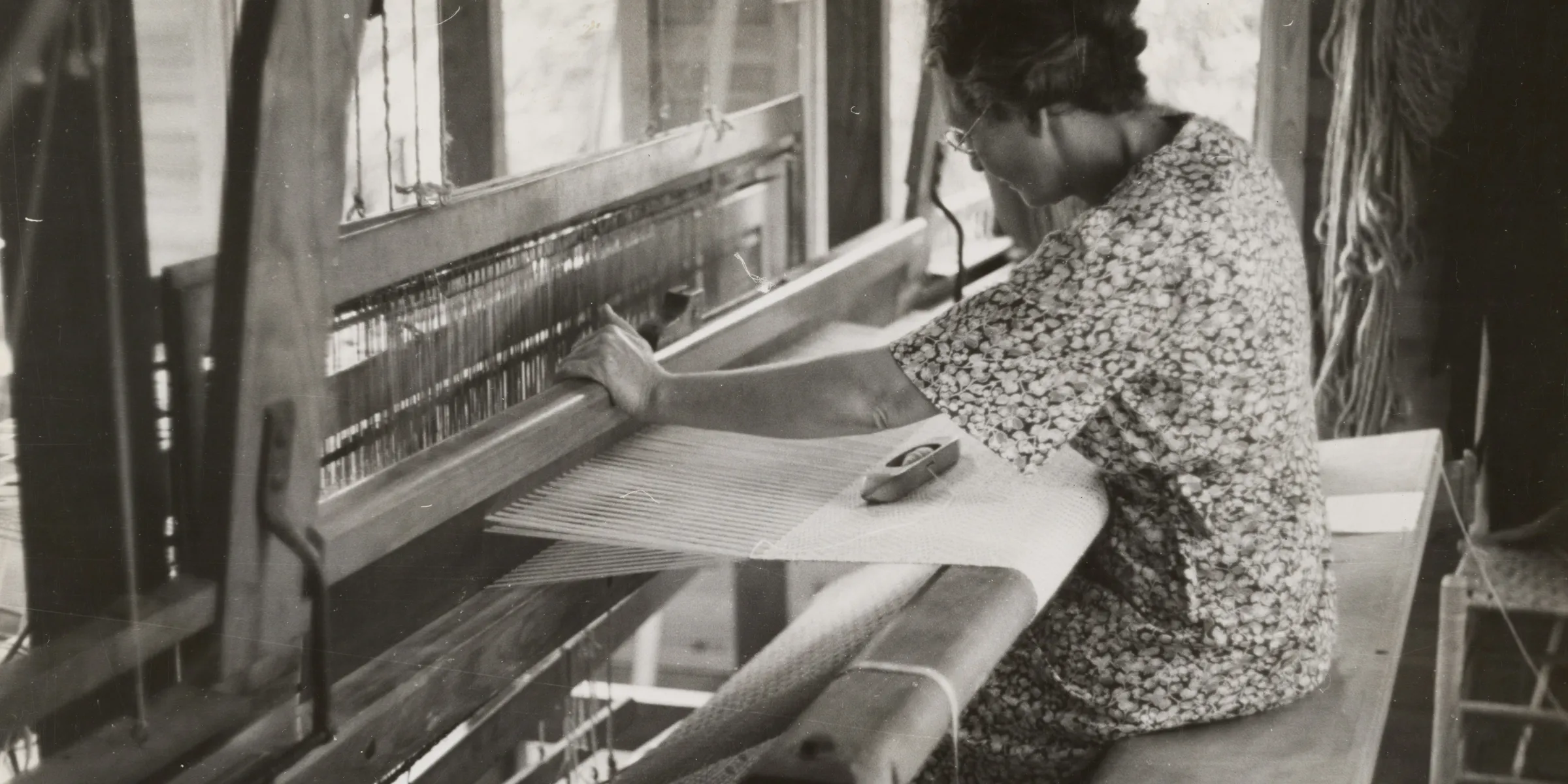 sitting woman using weaving machine