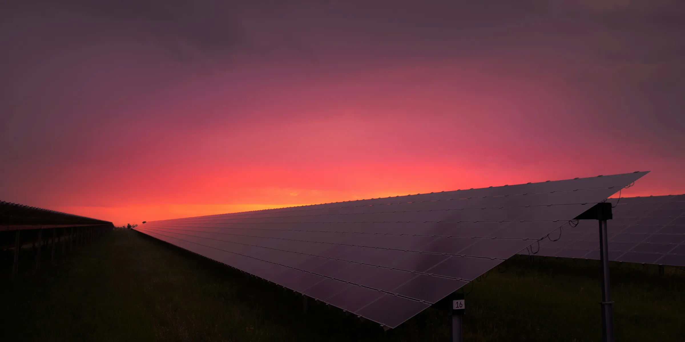 black solar panel under red and gray clouds