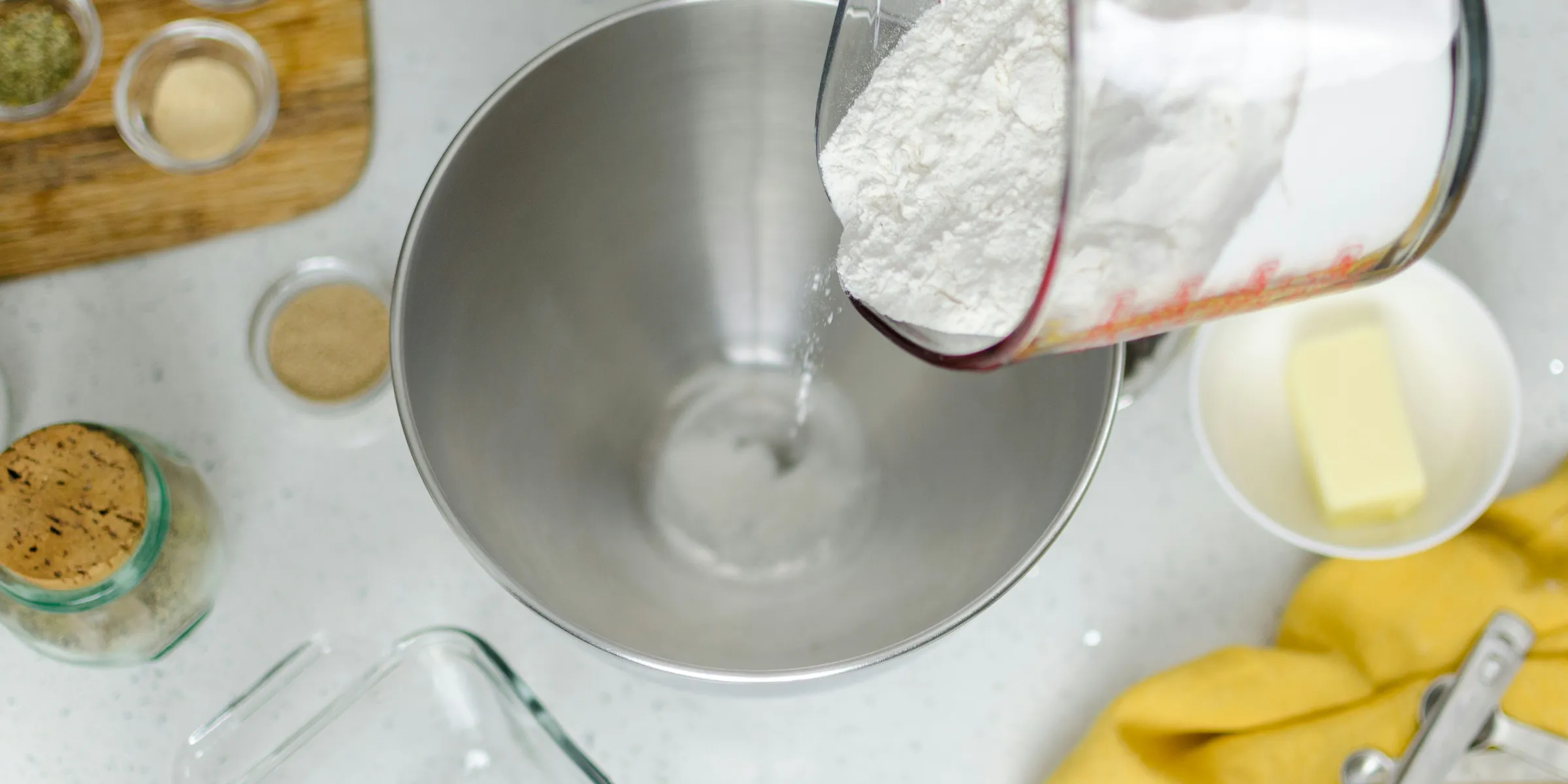 person pouring floor in mixing bowl