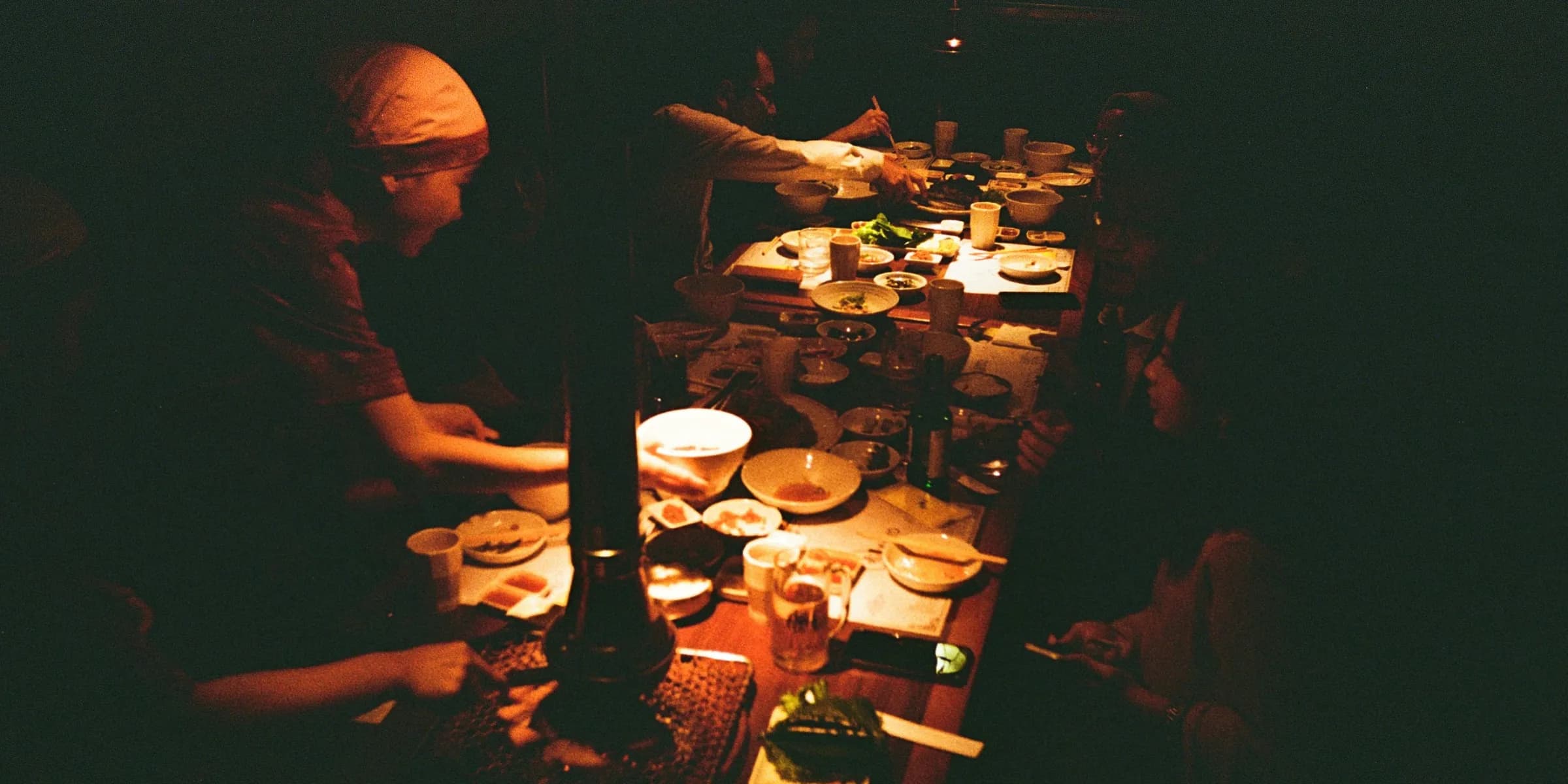 a group of people sitting at a table with plates of food