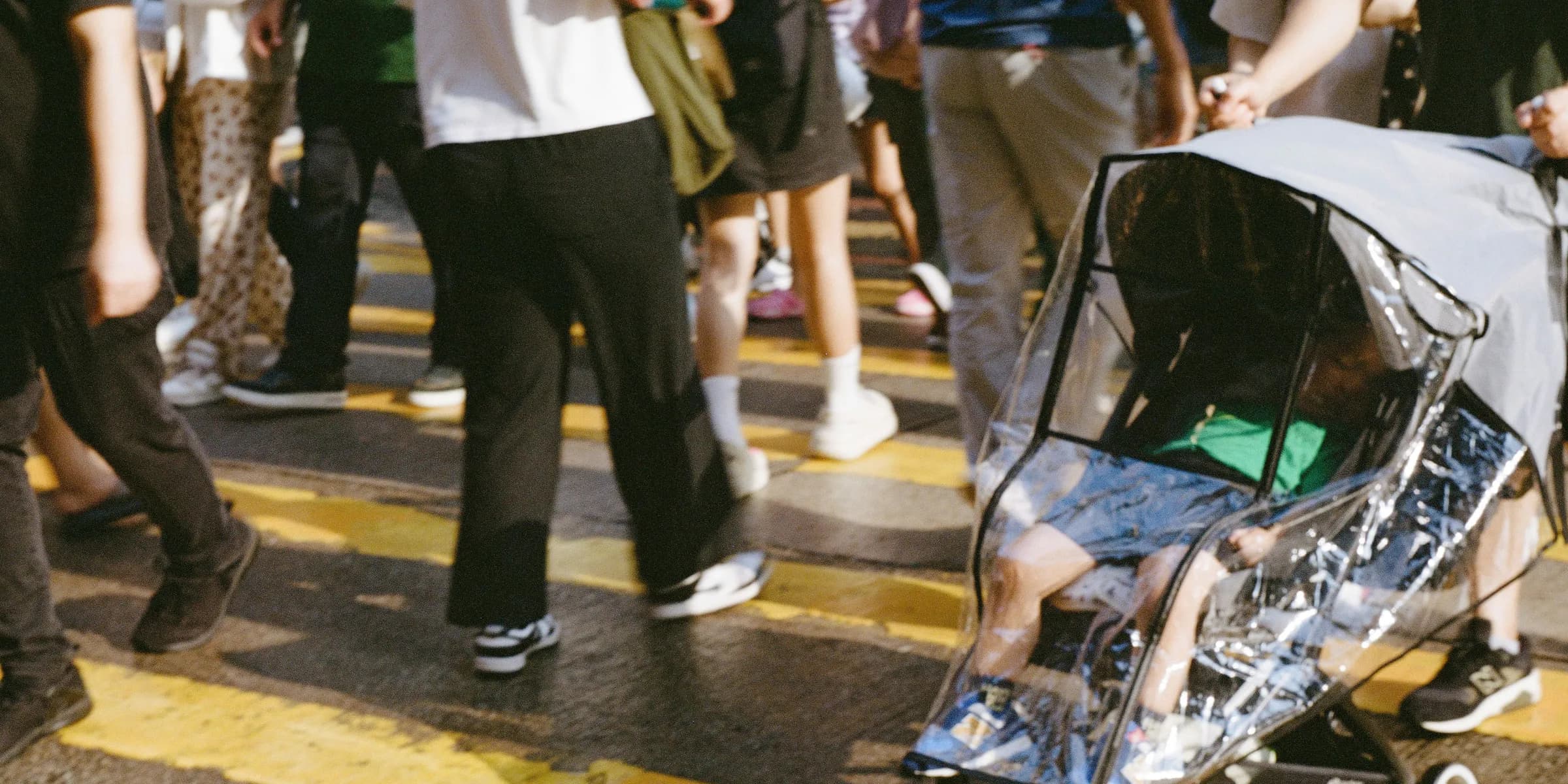 A group of people walking across a street