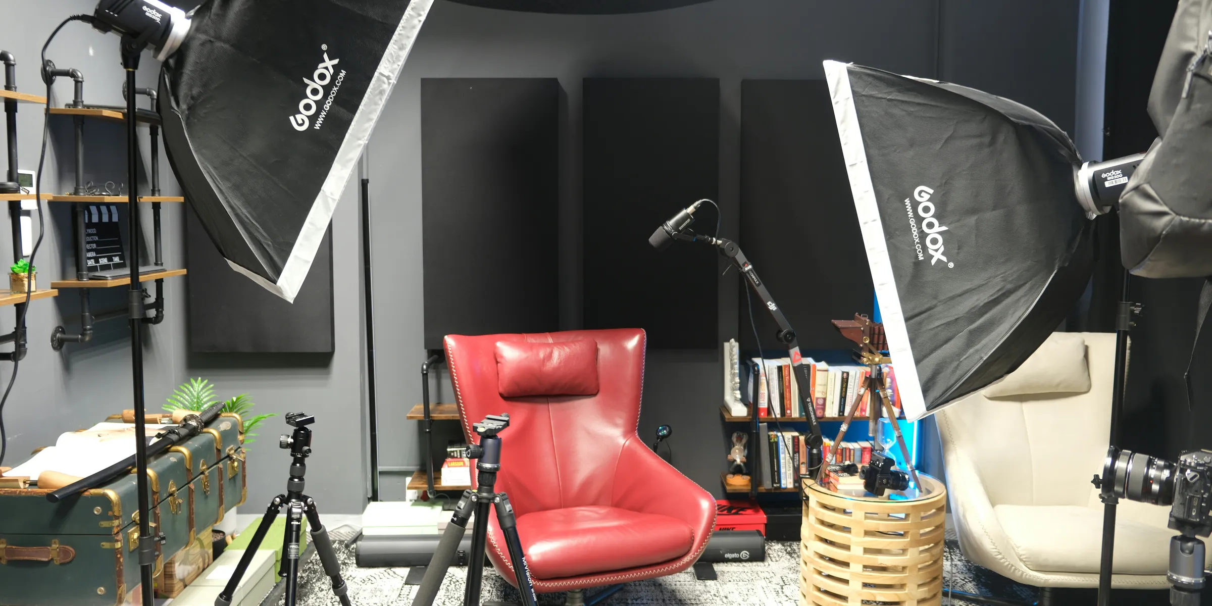 a photo studio with a red chair and umbrella
