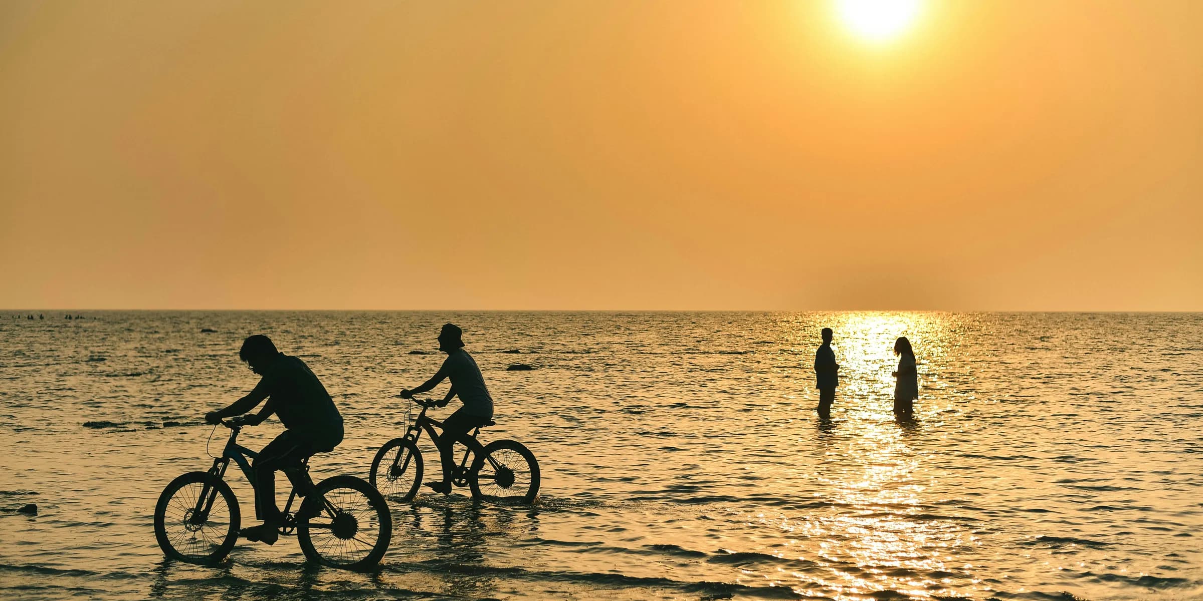 a group of people riding bikes in the water