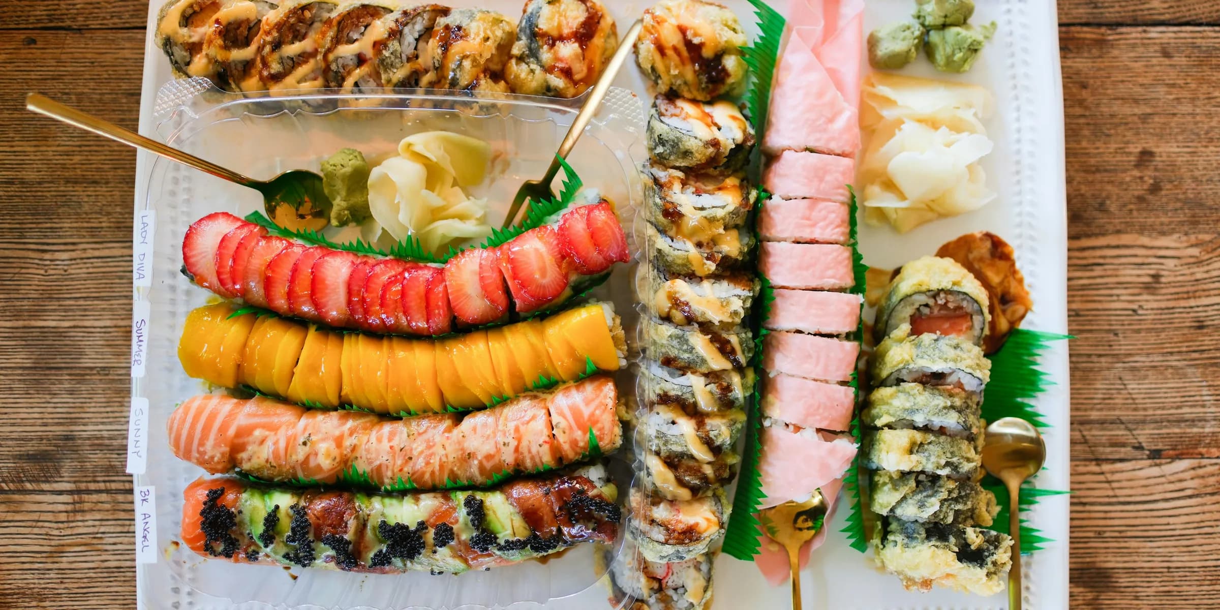 A large platter of assorted sushi rolls and appetizers.