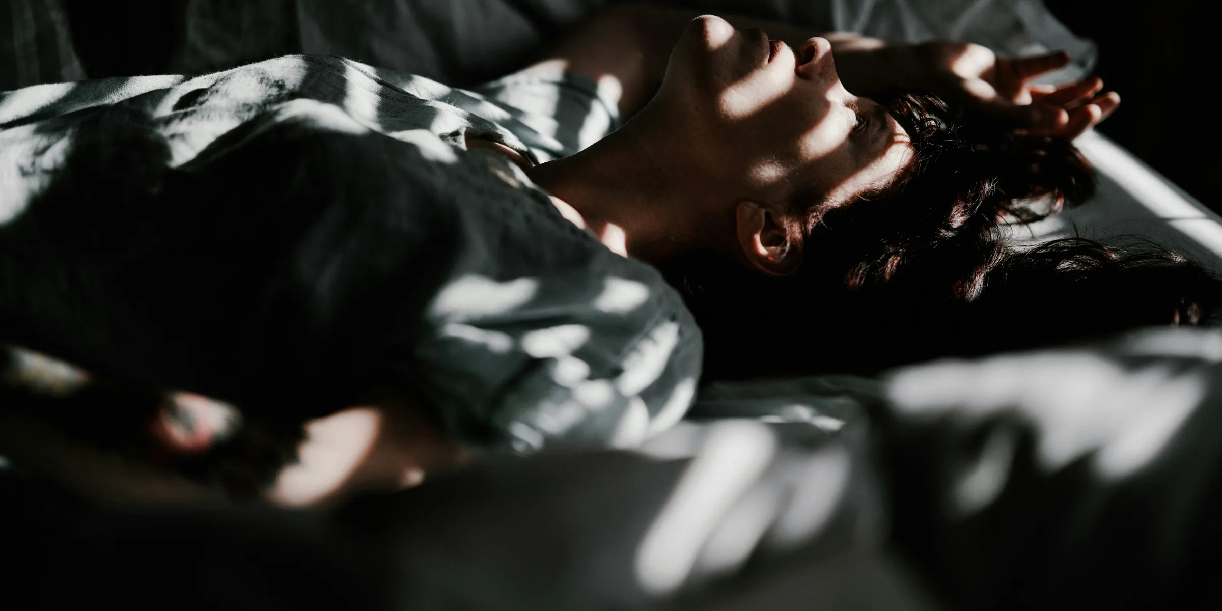 a person laying in bed with their head on a pillow