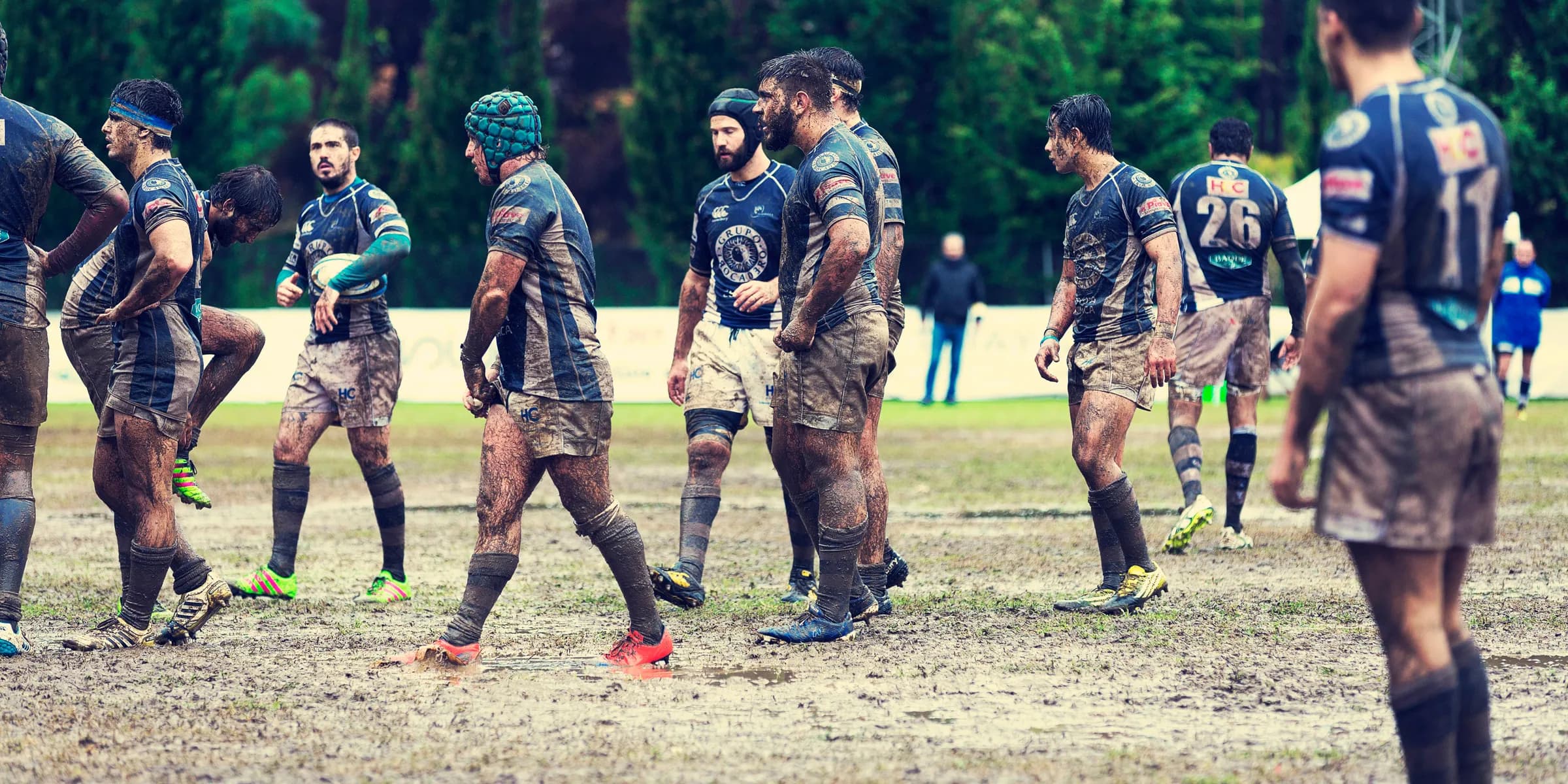 soccer players standing on muddy field